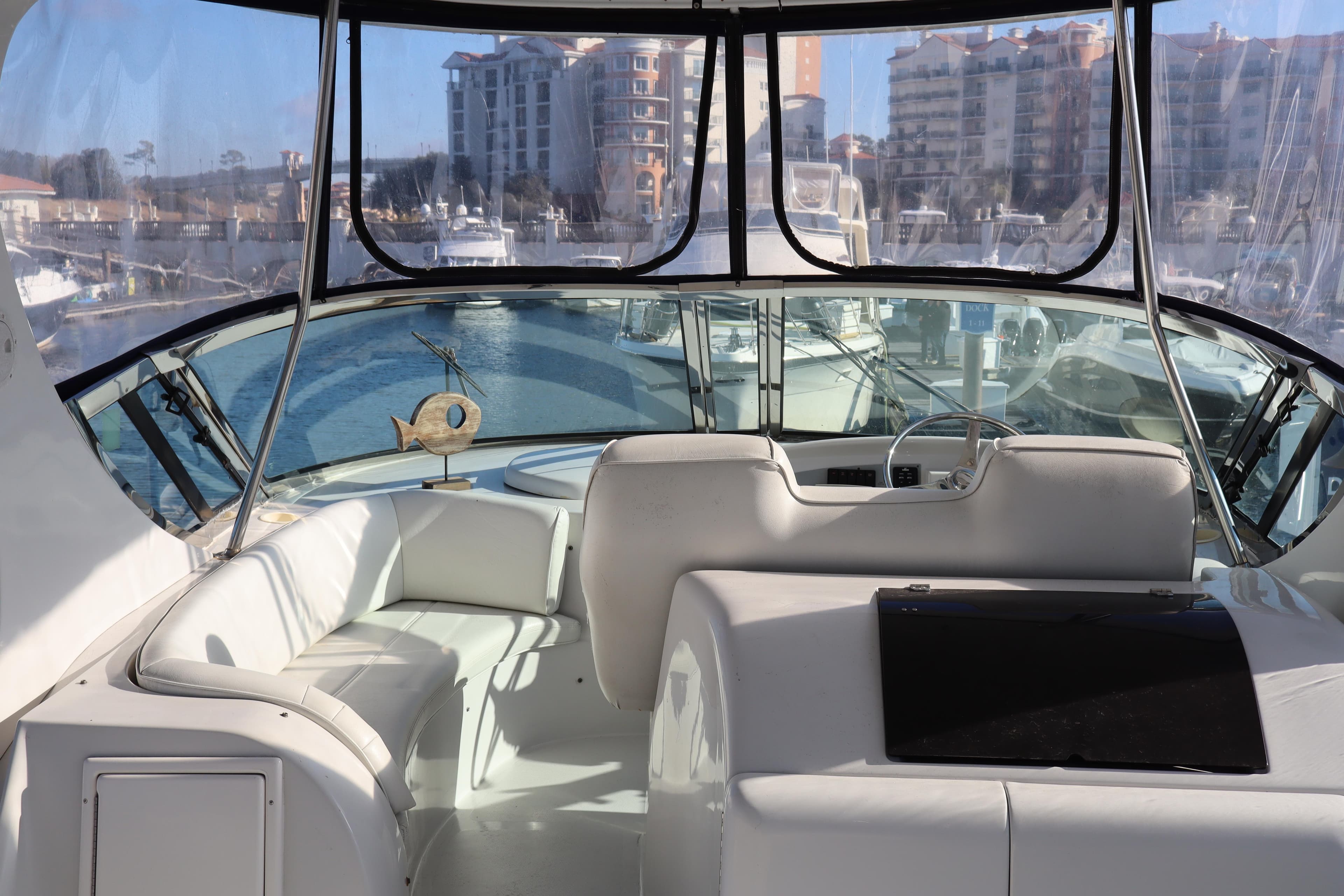 Interior view of 2006 Bluewater Yachts 5200, featuring a spacious cockpit and marina backdrop.