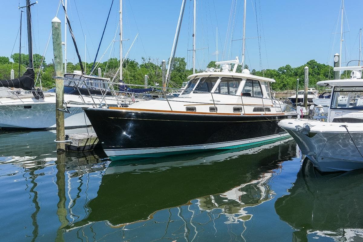 2006 Sabre 38 Hard Top Express yacht docked in a marina, surrounded by other boats.