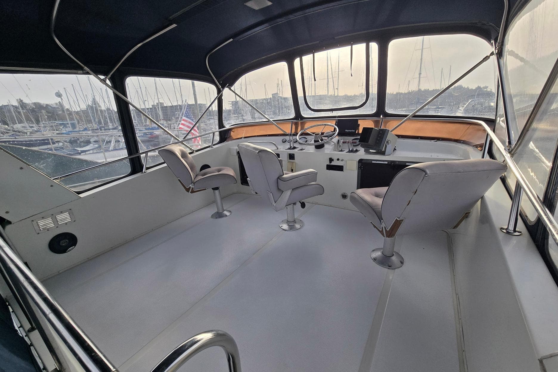 Interior of 1991 Cooper Marine Prowler boat with helm and seating, docked at marina.
