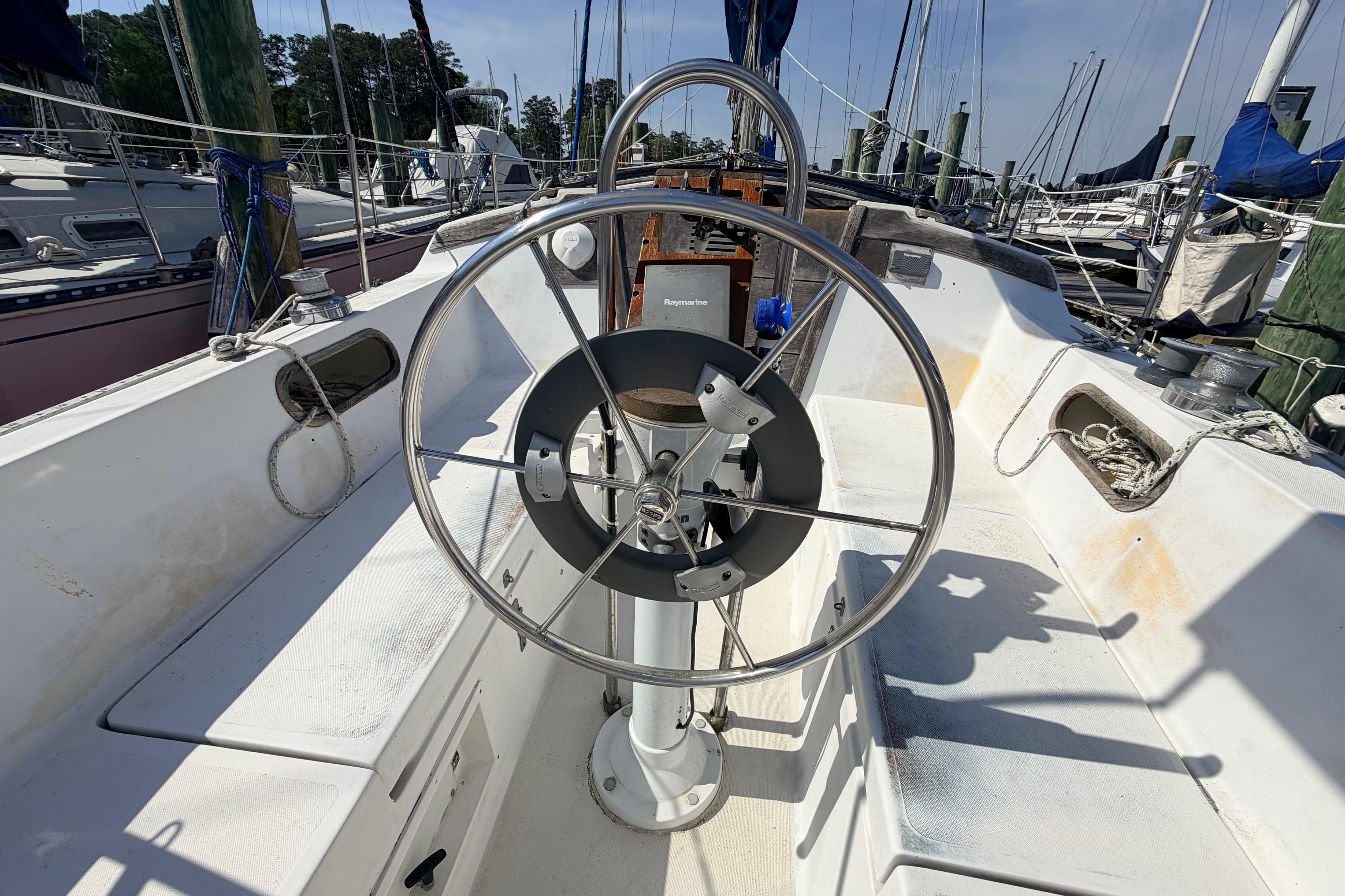Cockpit of a 1981 Catalina 30 sailboat with steering wheel and nautical equipment.