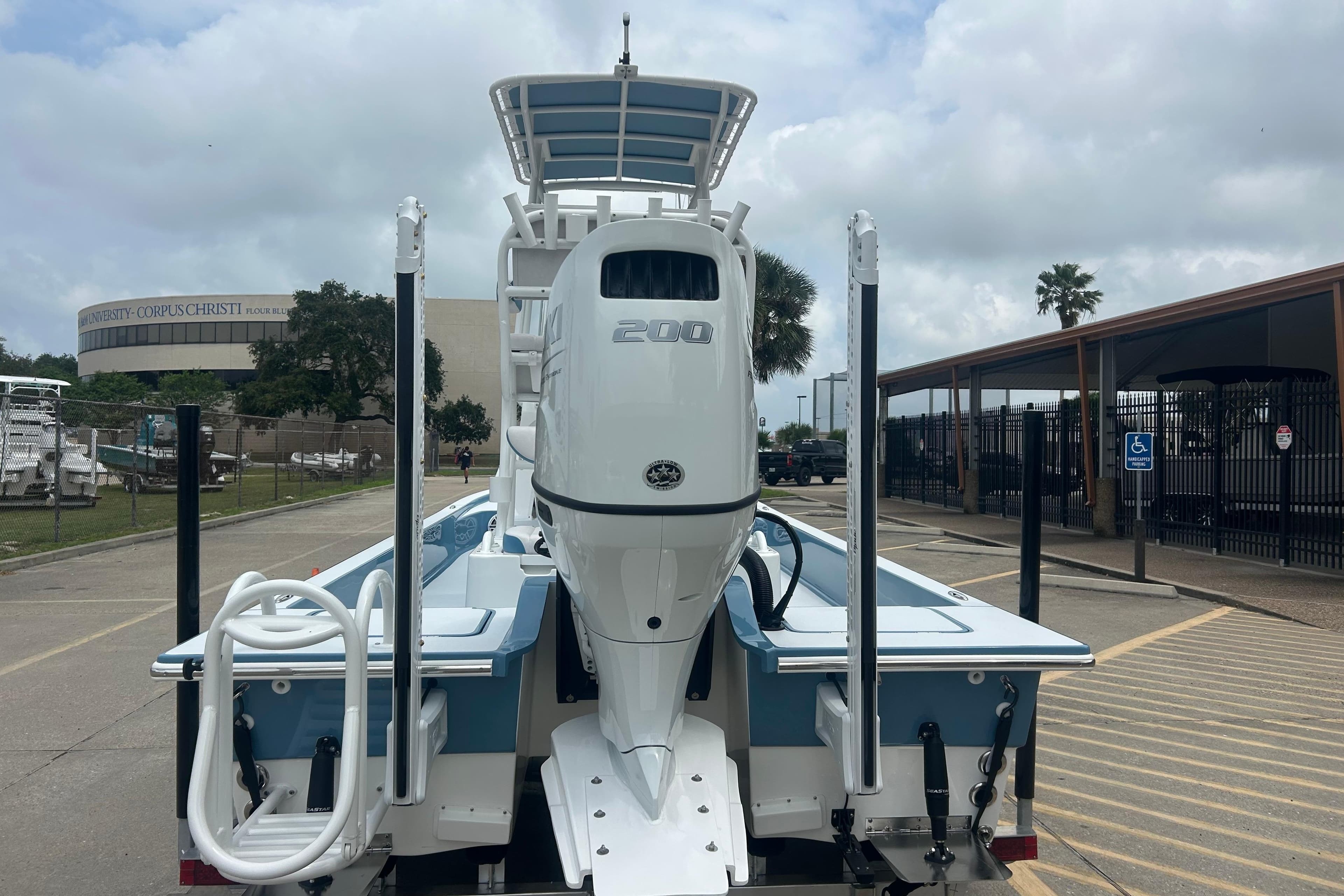 2026 Shallow Sport 22 Sport boat with powerful outboard motor, parked near university campus.