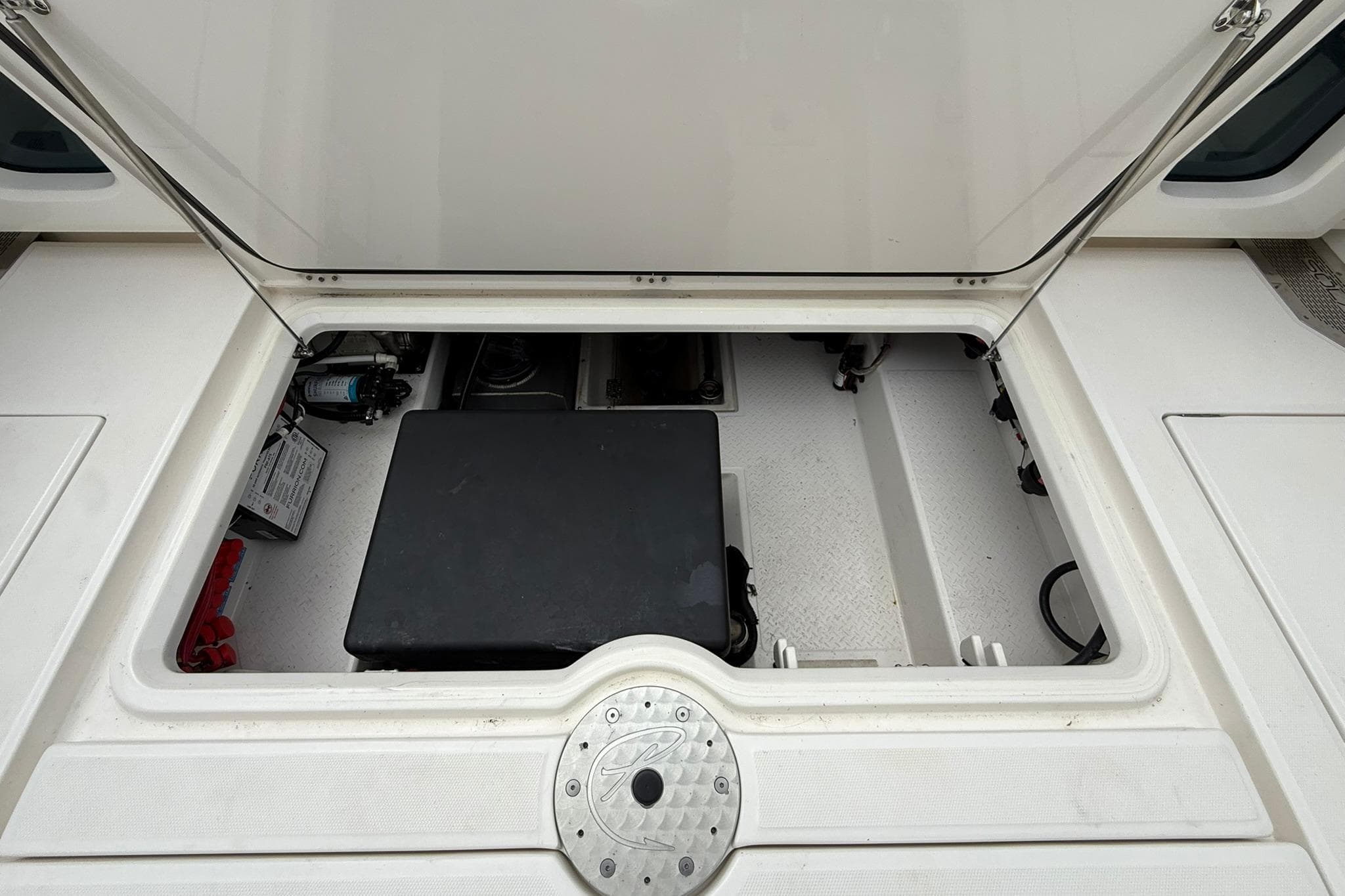 Open storage compartment of 2022 Solace 41CS boat, showcasing interior equipment and components.