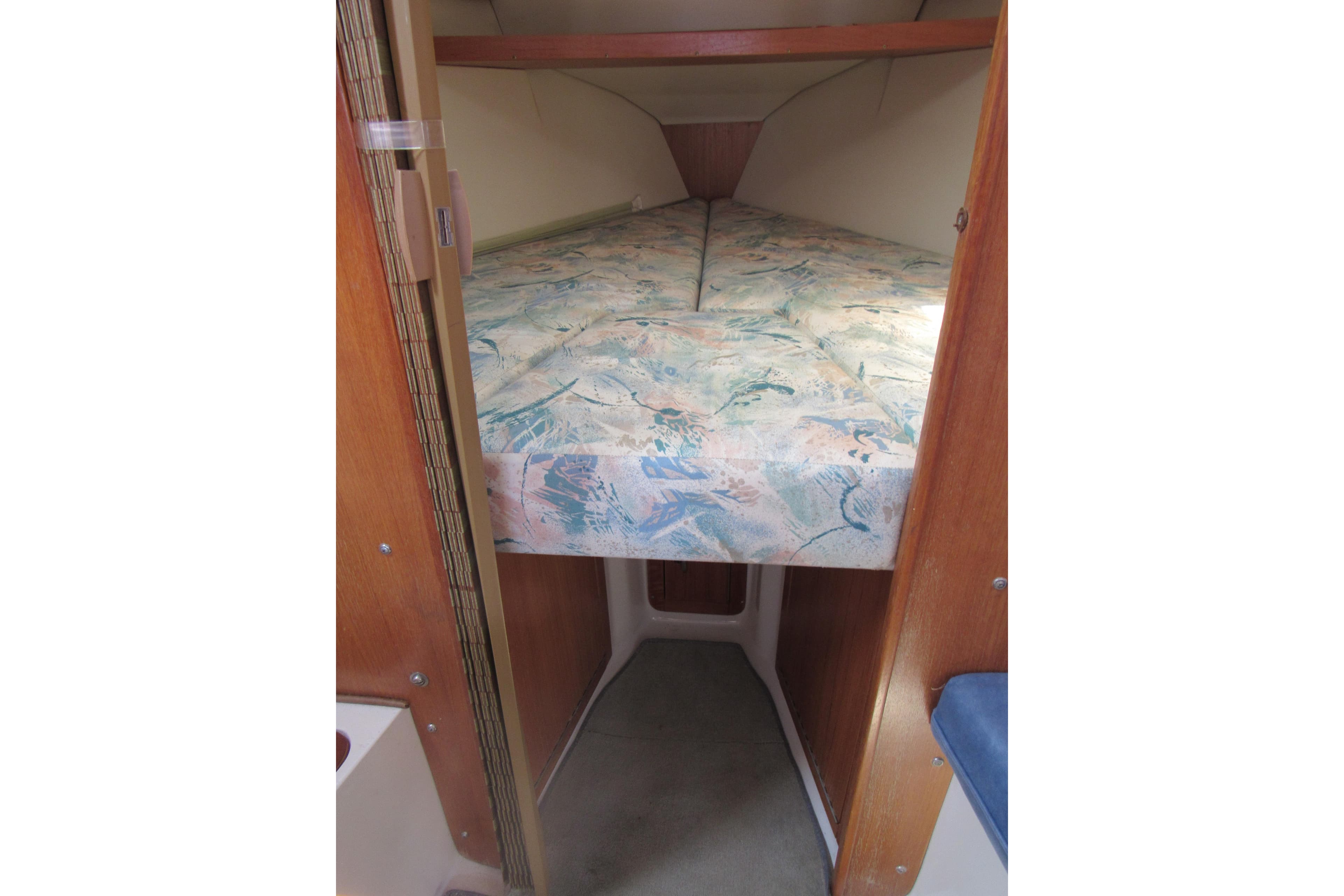 1997 Catalina 28 MkII sailboat interior with V-berth and patterned bedding.