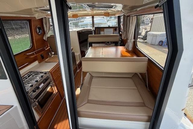 Interior of 2023 Ranger Tugs R-27 boat, featuring kitchen and seating area.