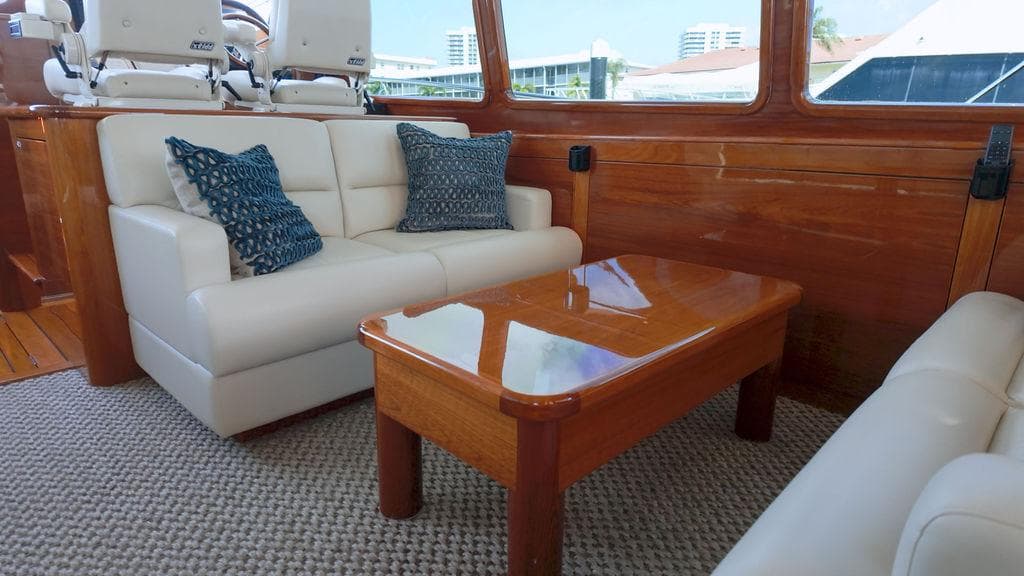 Luxurious interior of 2018 Palm Beach Motor Yachts PB55 Flybridge with elegant seating and wooden table.