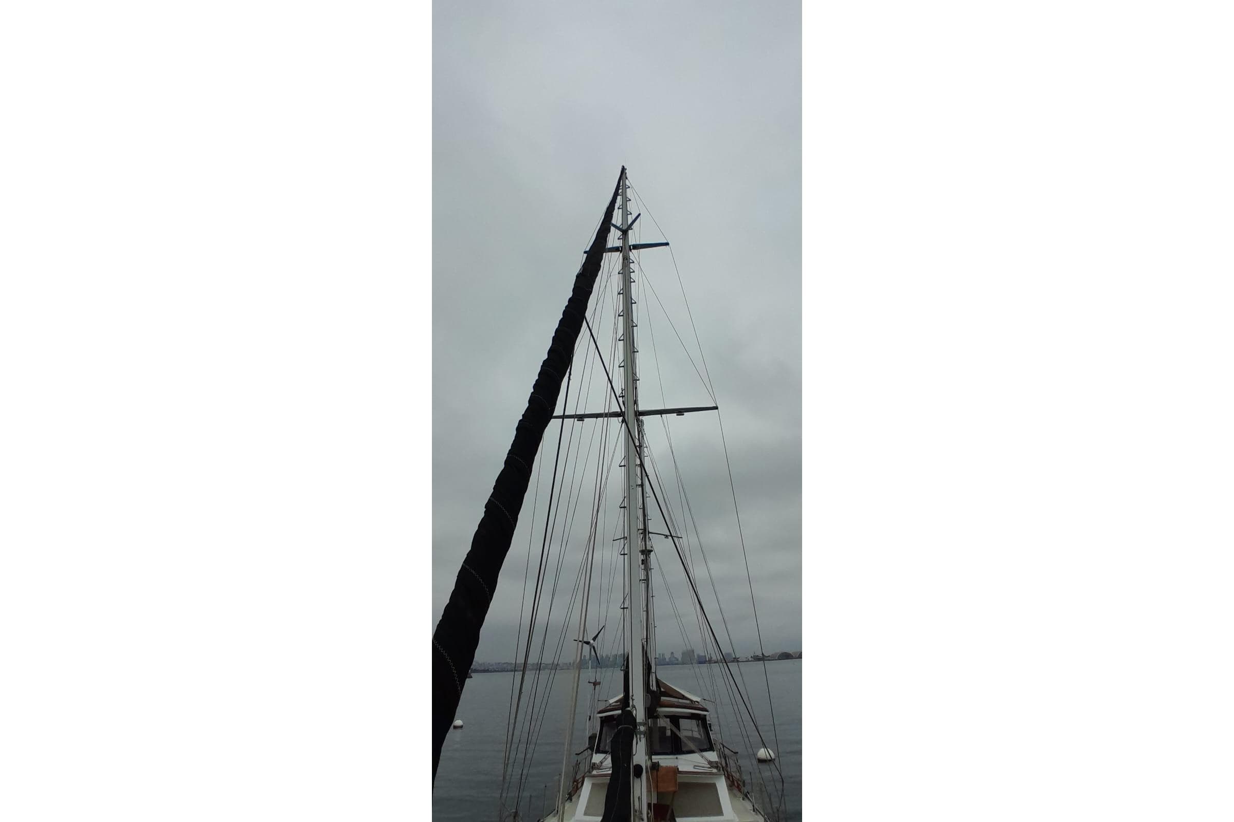 Mast of 1974 Force Hudson 50 sailboat against cloudy sky.