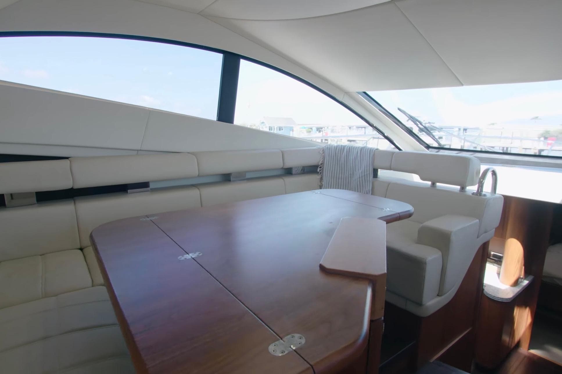 Luxurious interior of 2014 Sunseeker Manhattan 55 yacht with elegant seating and wooden table.