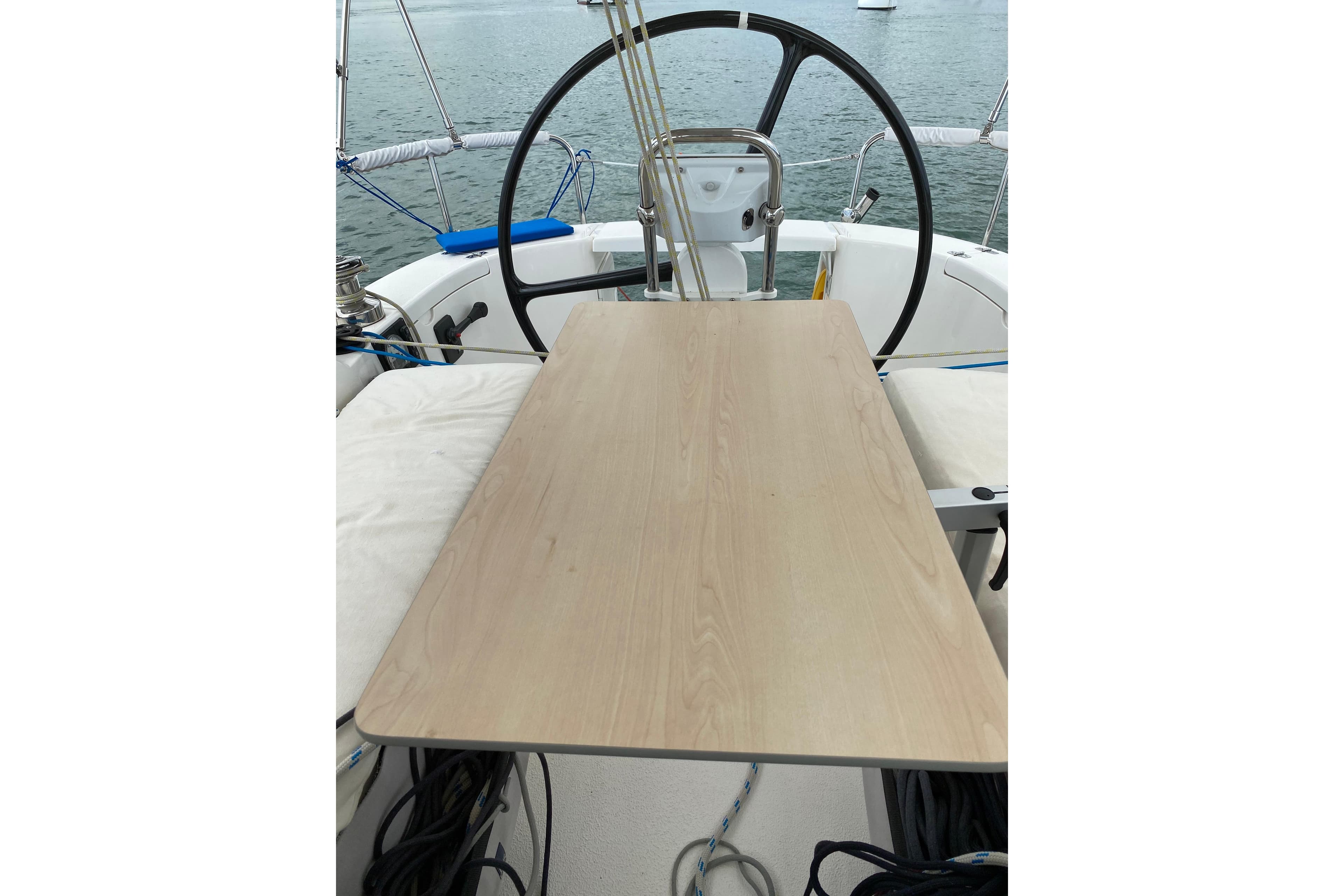 Cockpit view of 2016 Dragonfly 32 Supreme sailboat with wooden table and steering wheel.