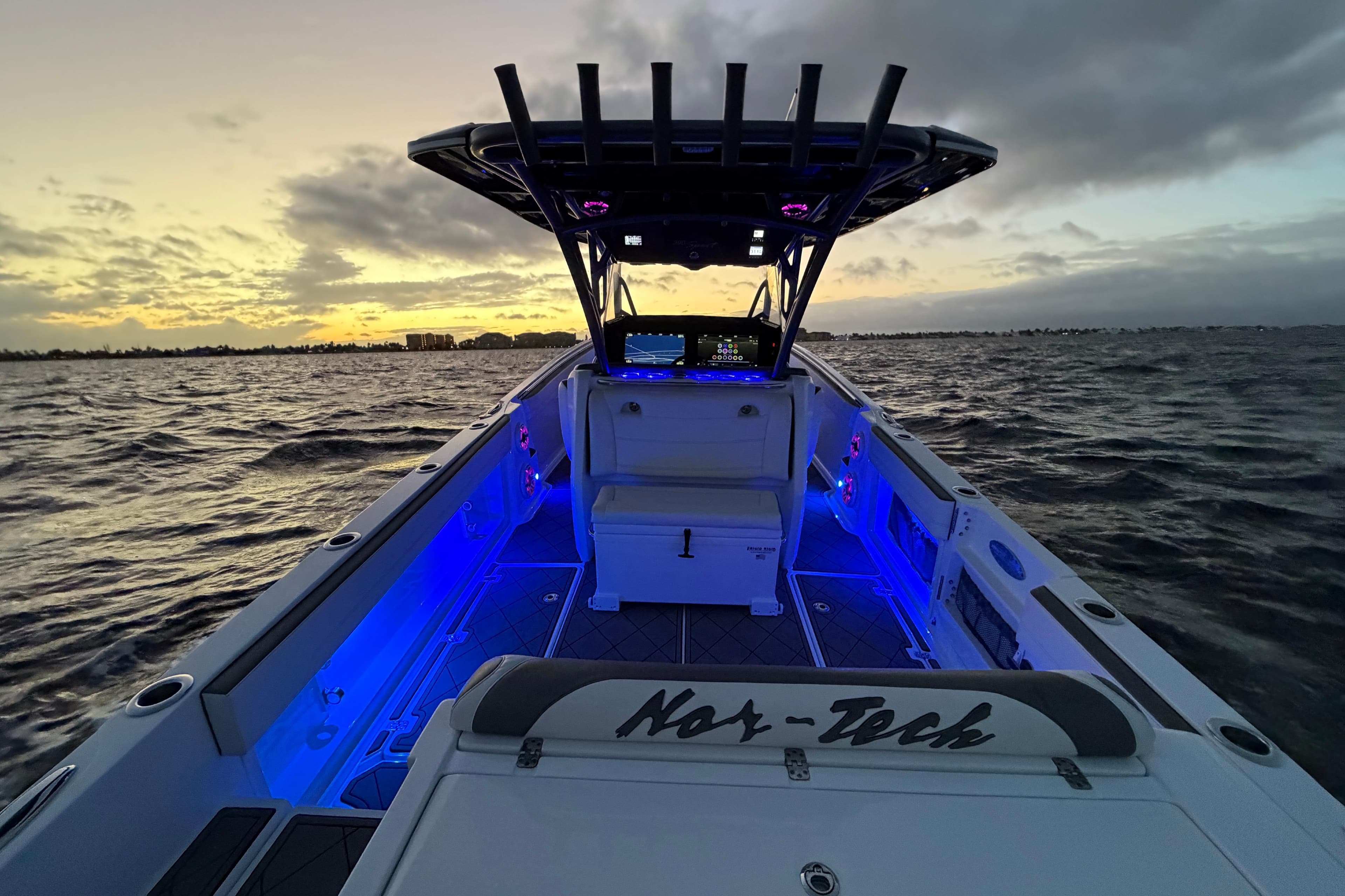 2021 Nor-Tech 390 Sport Center Console boat at sunset with blue interior lighting.