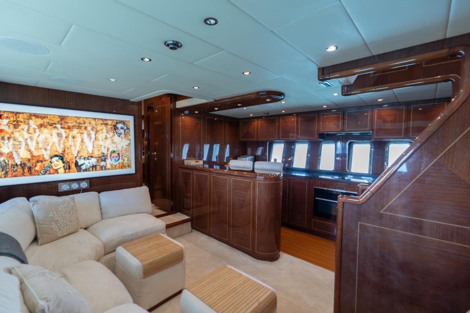 Luxurious interior of 2004 Mangusta 72 yacht with elegant wood finishes and plush seating.
