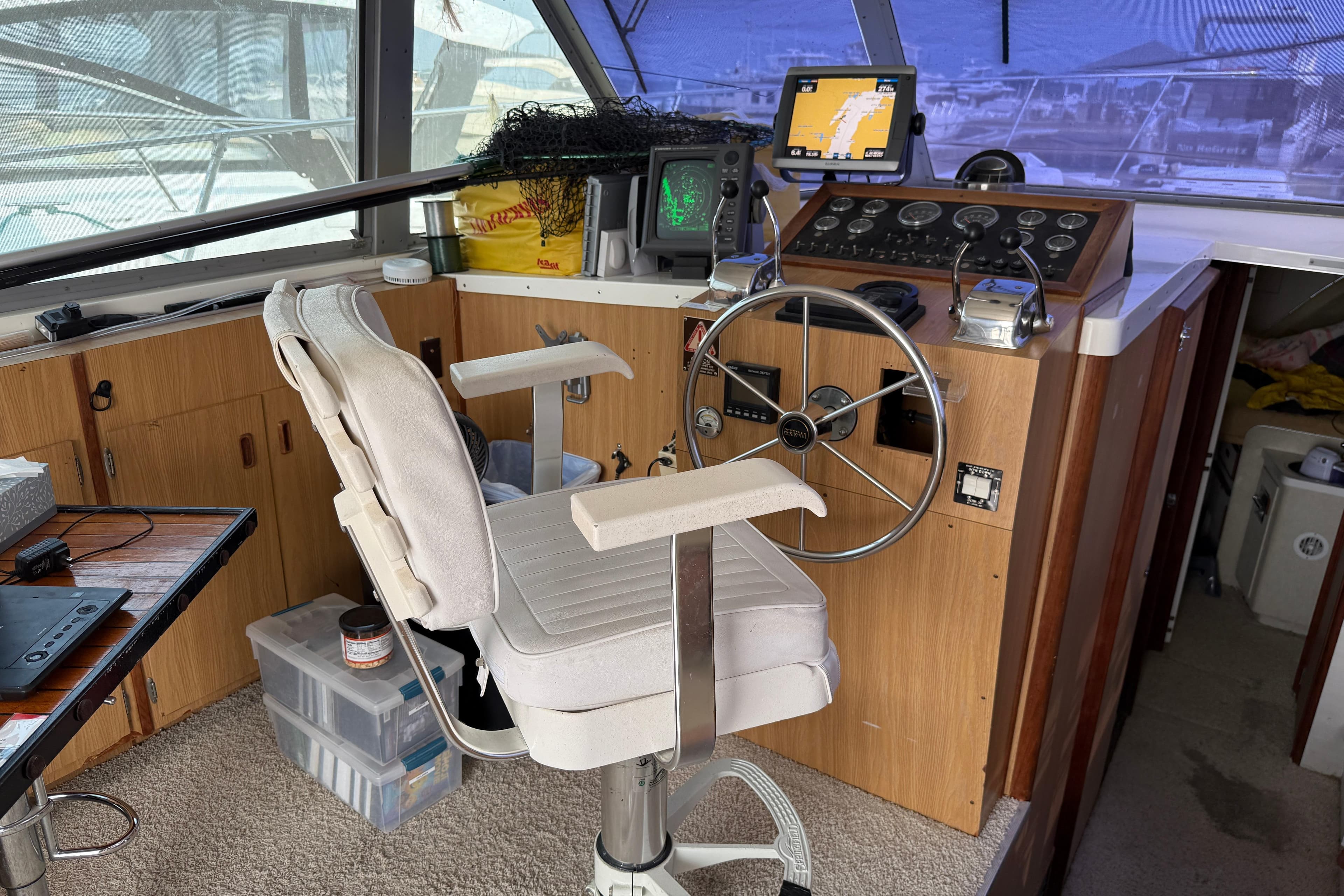 1978 Bertram 42 Convertible helm with steering wheel, navigation equipment, and captain's chair.