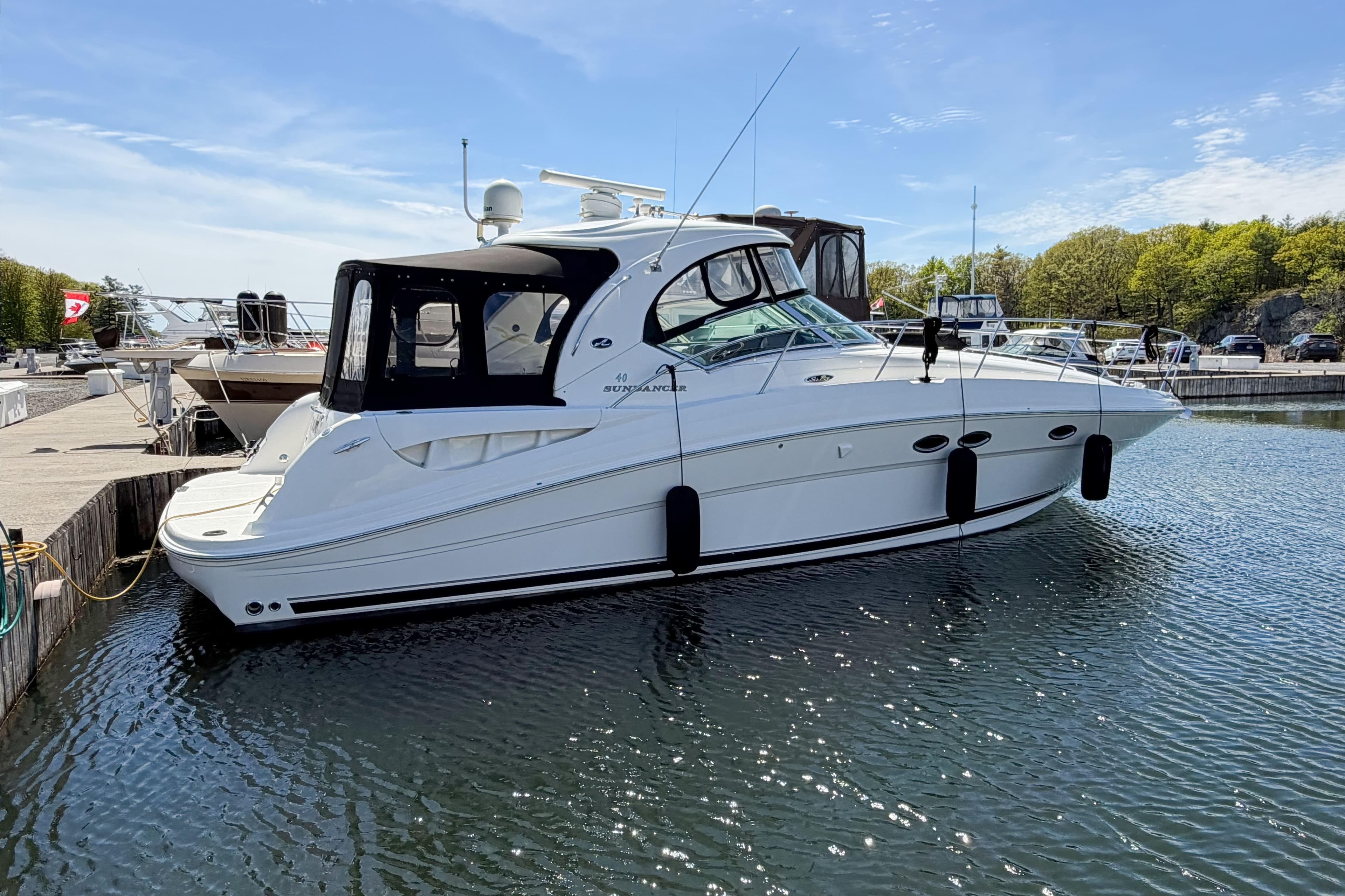 2005 Sea Ray 40 Sundancer yacht docked in a marina under clear blue skies.