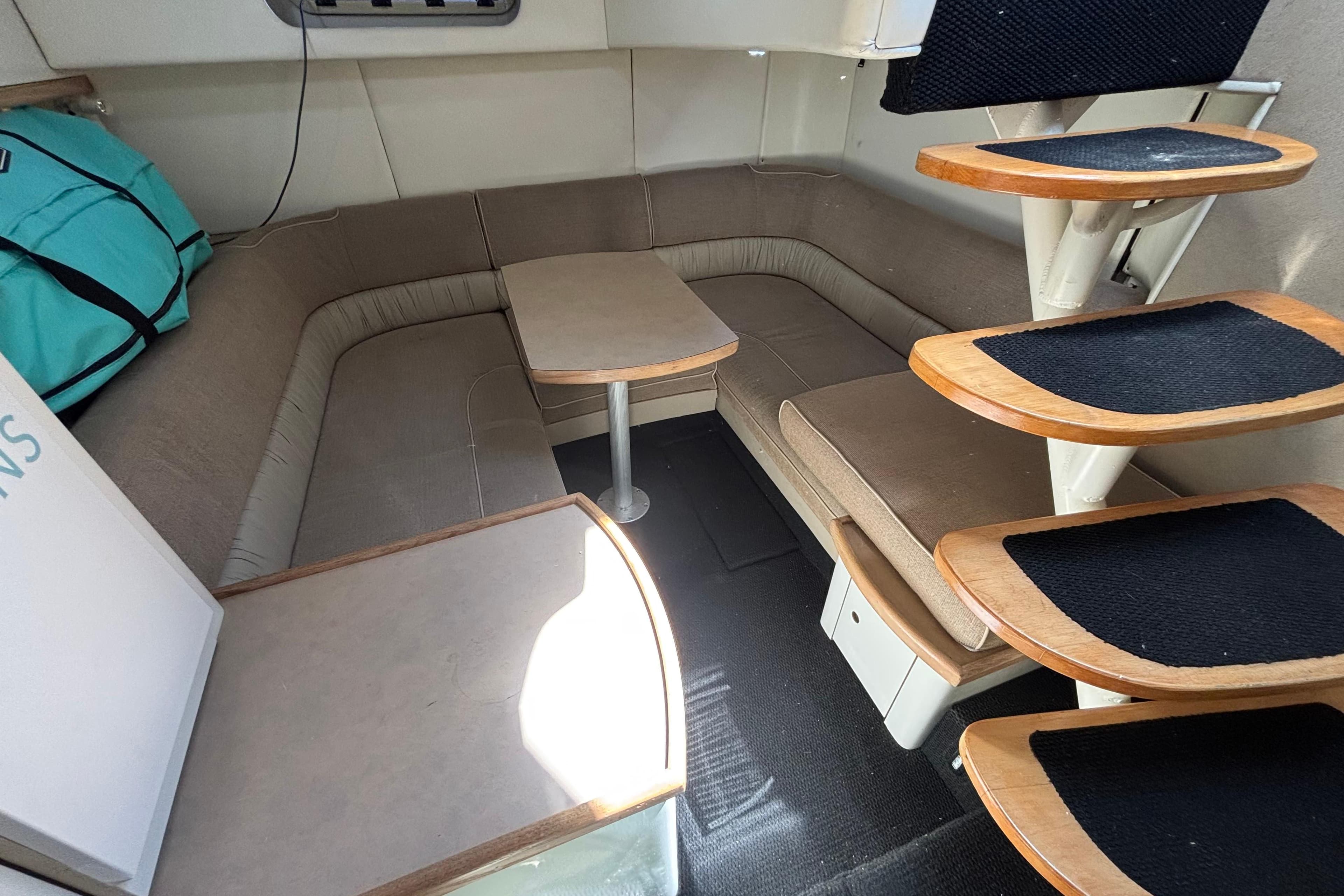 Interior of 1997 Maxum 4100 SCR yacht with cozy seating and wooden steps.
