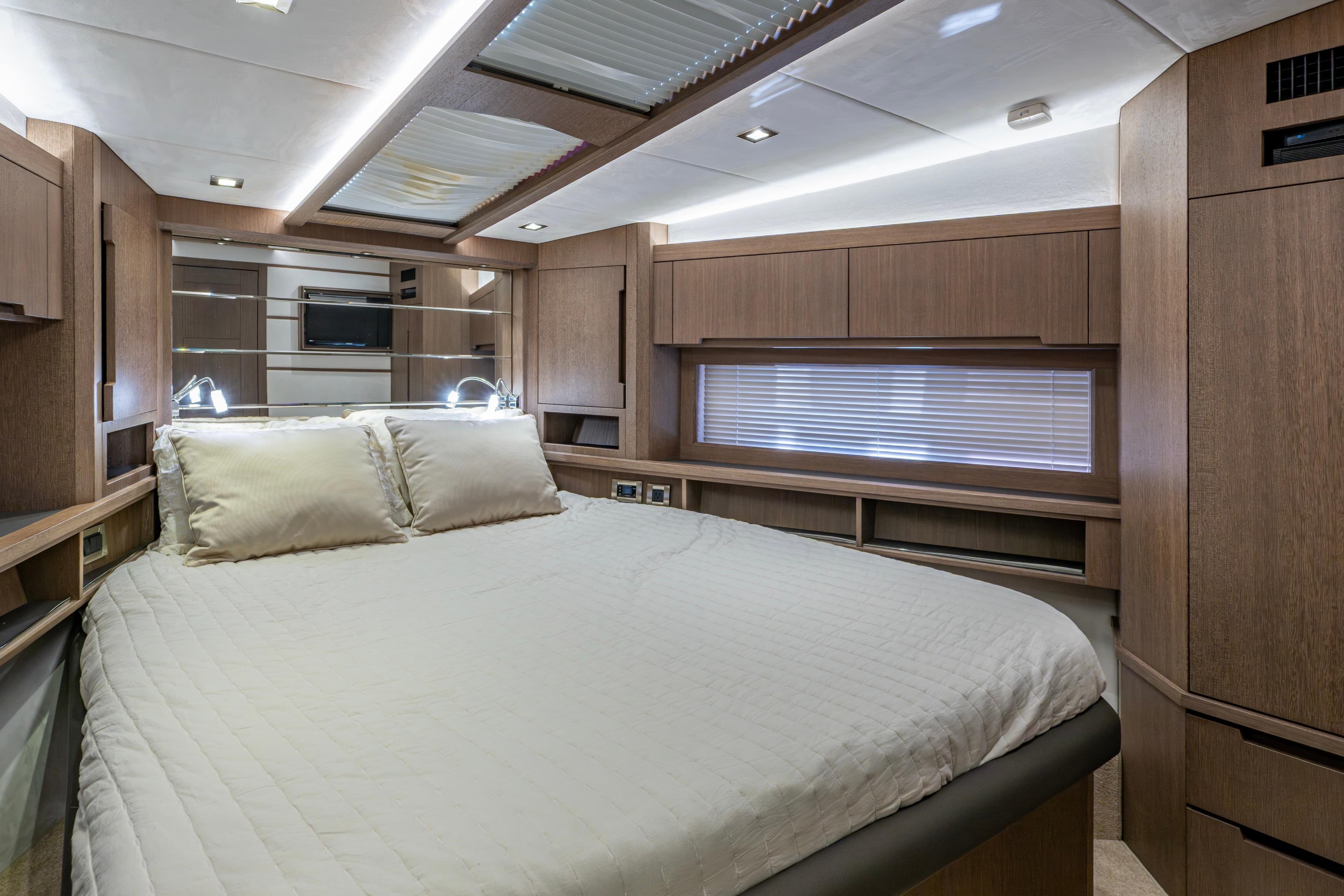 Luxurious bedroom interior of 2020 Galeon 550 Fly yacht with modern wood finishes.