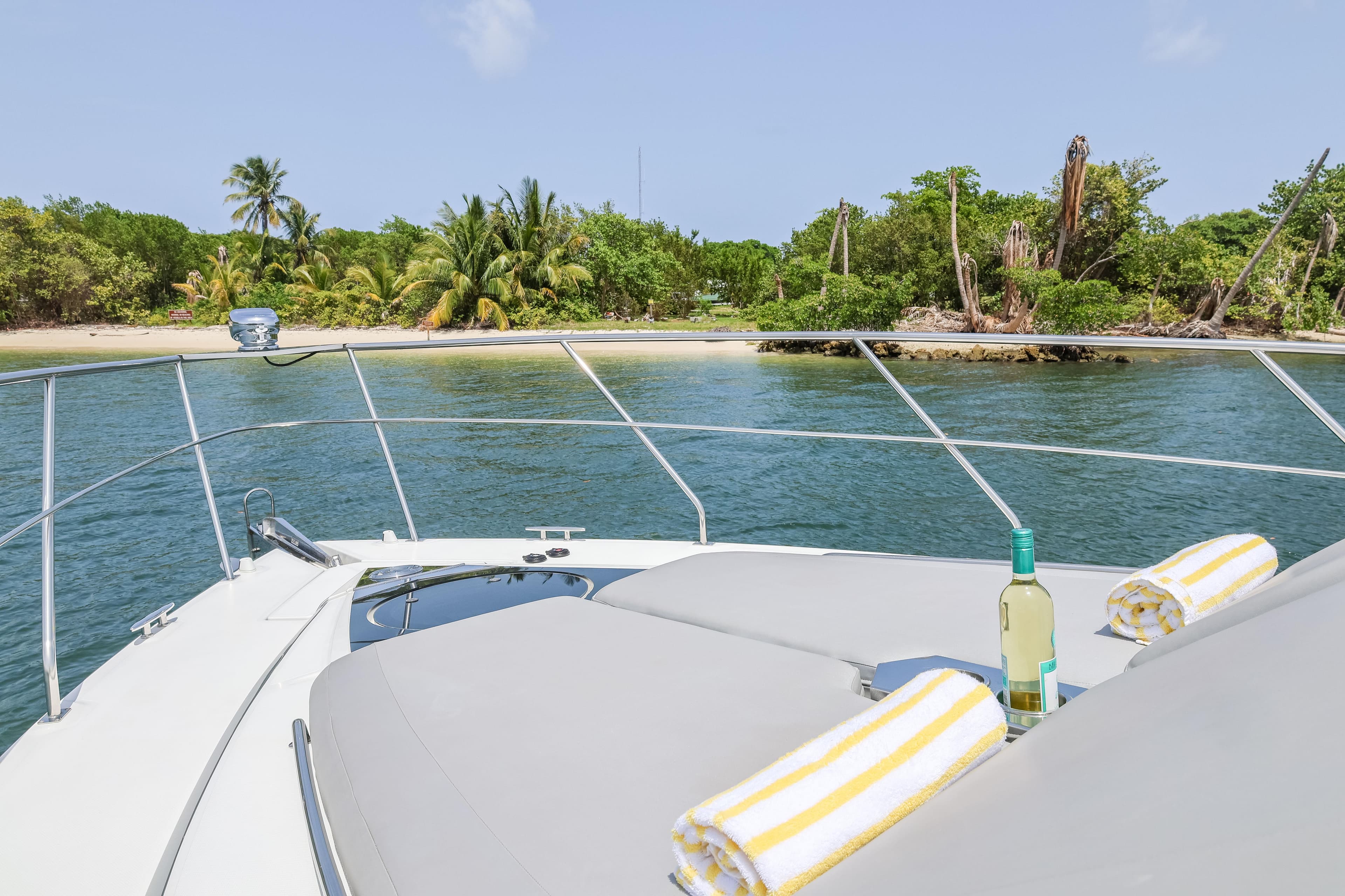 Luxury 2014 Cruisers Yachts 45 Cantius anchored near tropical island with wine and towels.