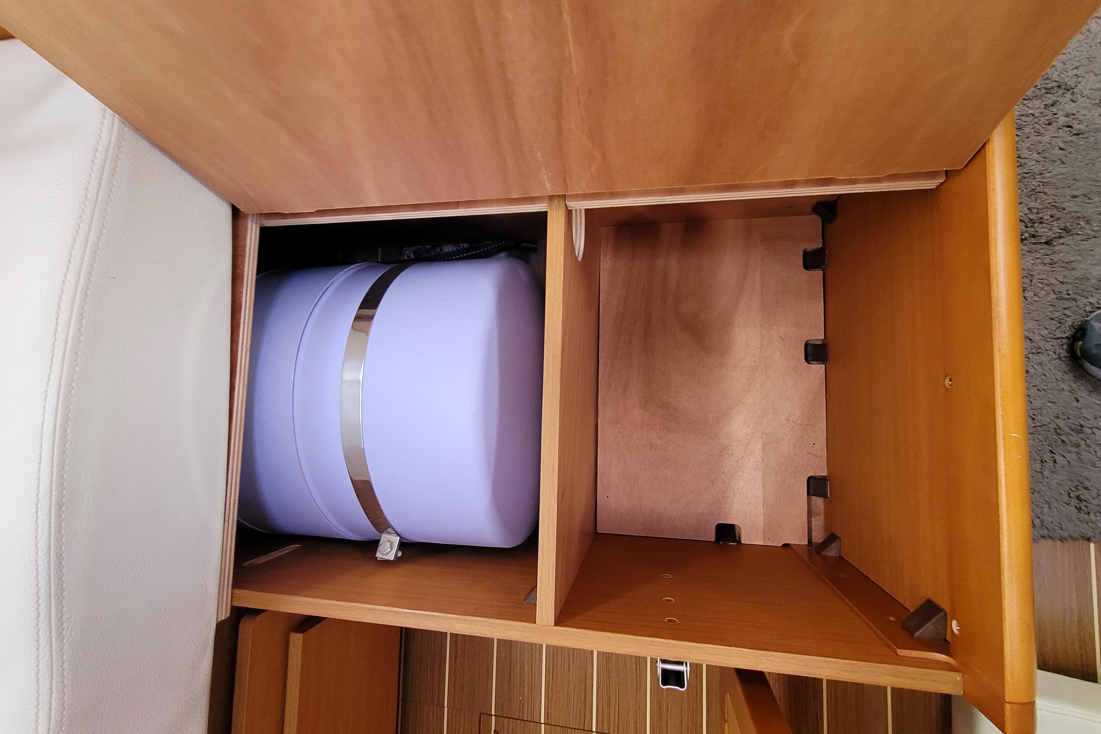 Wooden storage compartment in a 2014 Jeanneau 379 sailboat interior.