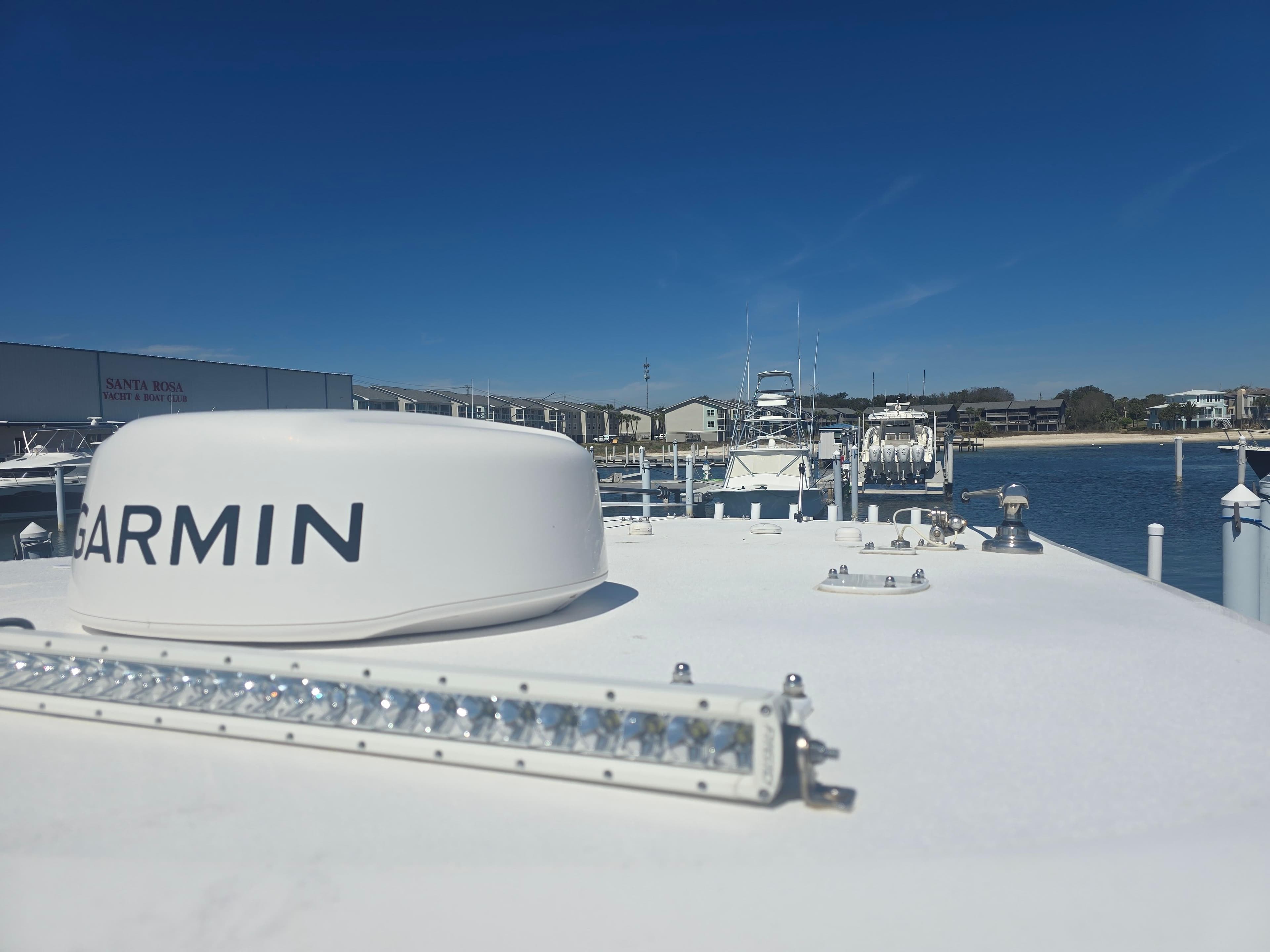 2024 Invincible 43 Open Fisherman boat with Garmin equipment, docked under clear blue sky.