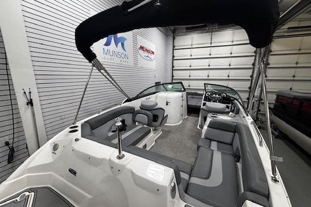 2023 NauticStar 243DC Sport Deck boat in showroom, featuring sleek seating and modern design.