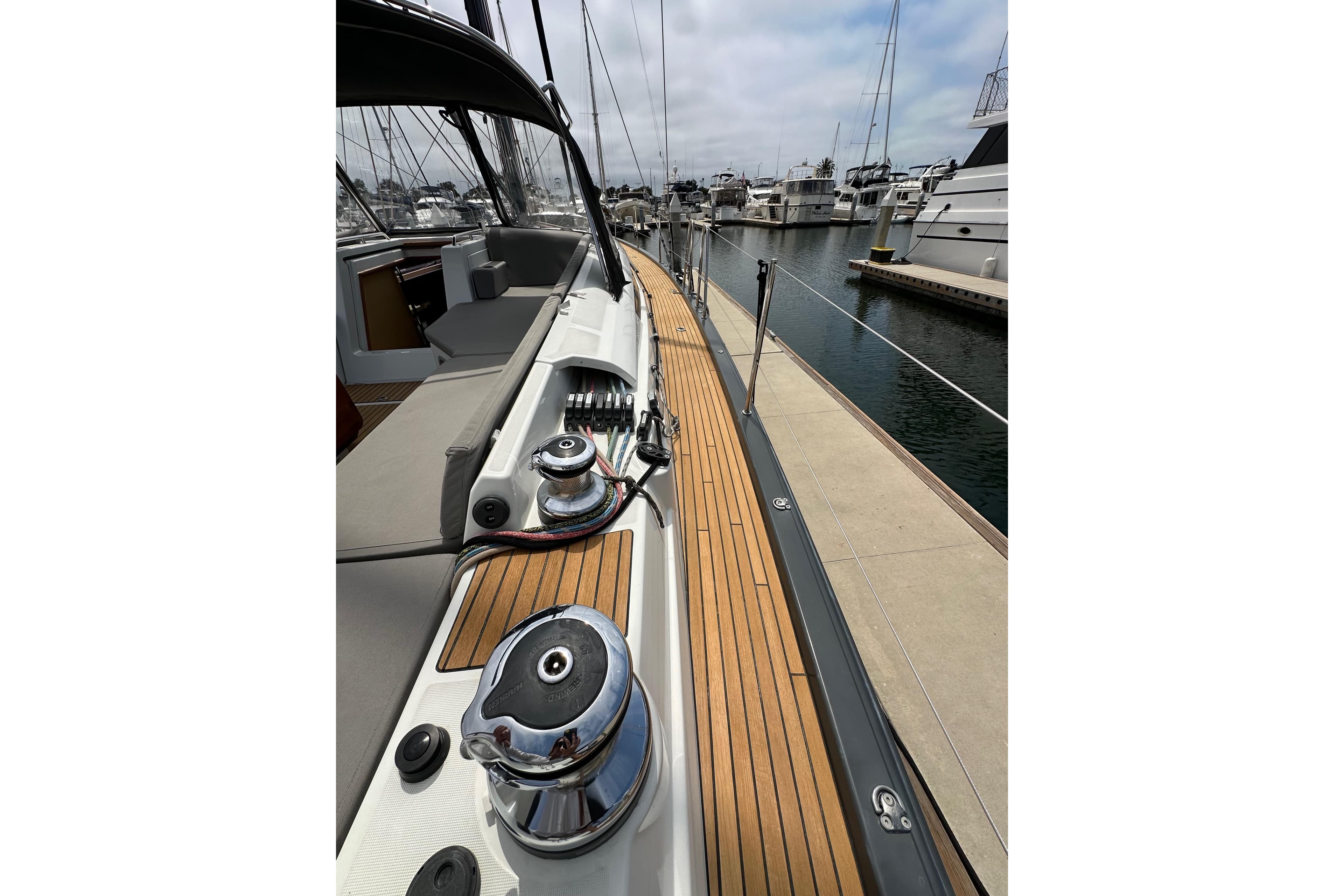 Jeanneau 54 sailboat deck, 2018 model, docked at marina with polished winches.