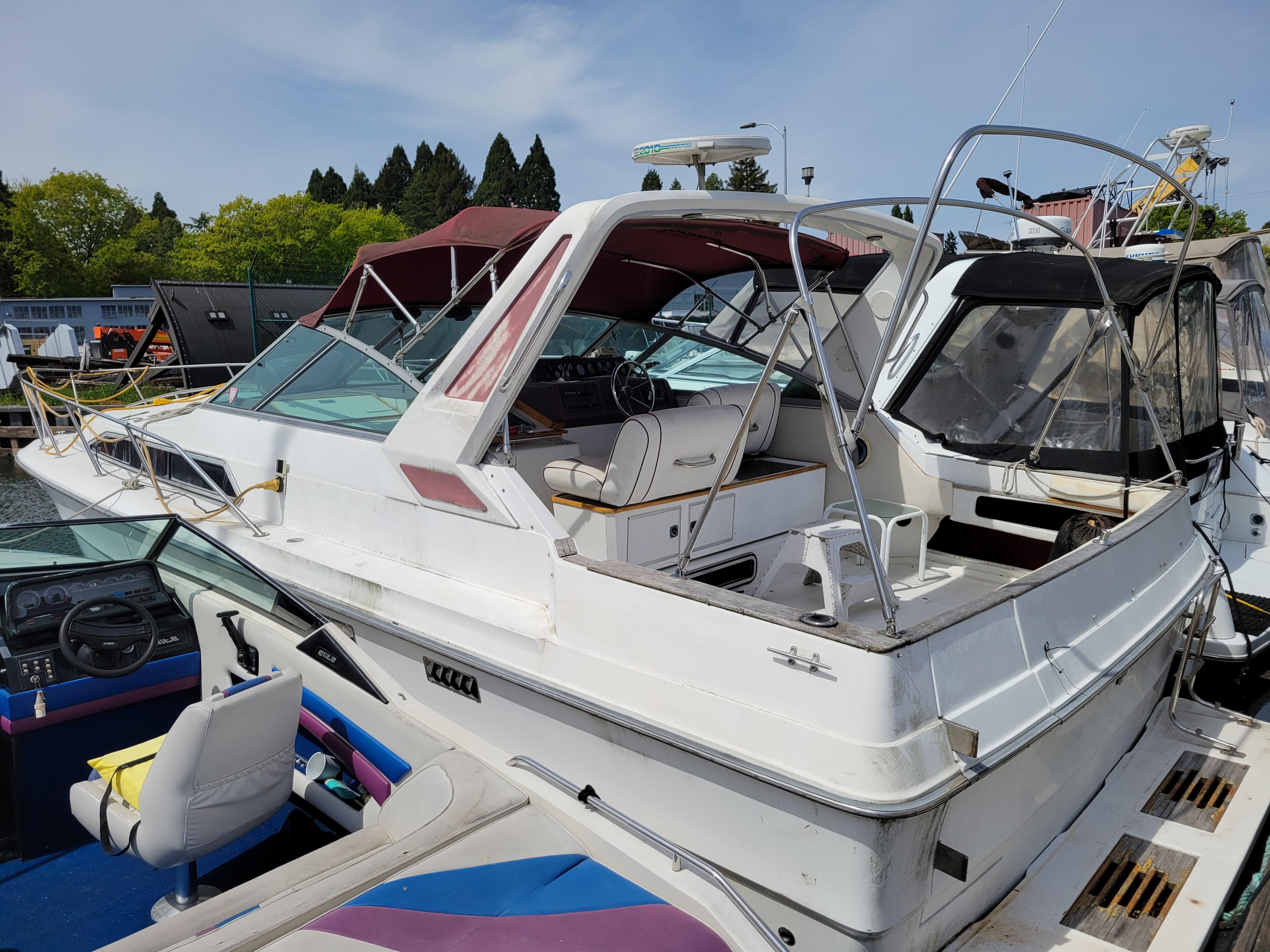 1989 Sea Ray 340 Sundancer boat docked, featuring a spacious cockpit and sleek design.