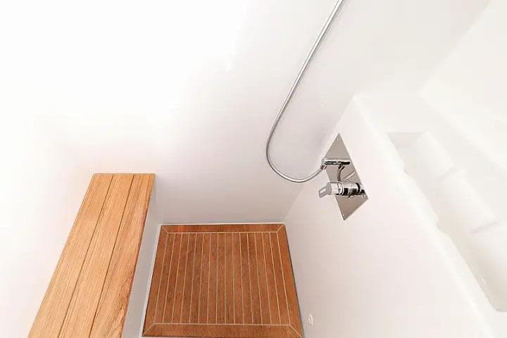 Modern shower area with wooden bench and floor in Lagoon 620 Esense yacht.