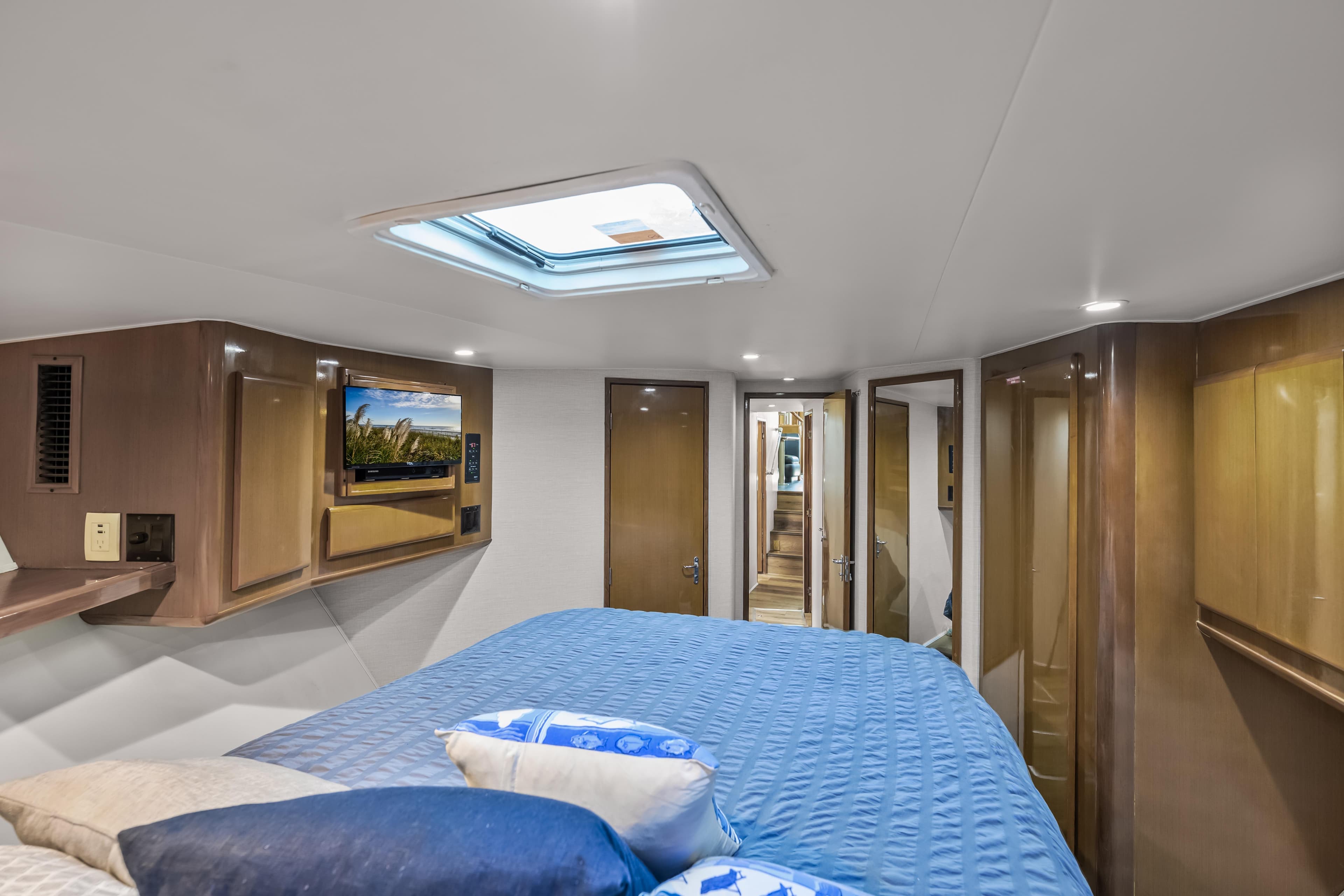 Luxurious cabin interior of 1999 Viking 58 Convertible yacht with skylight and TV.