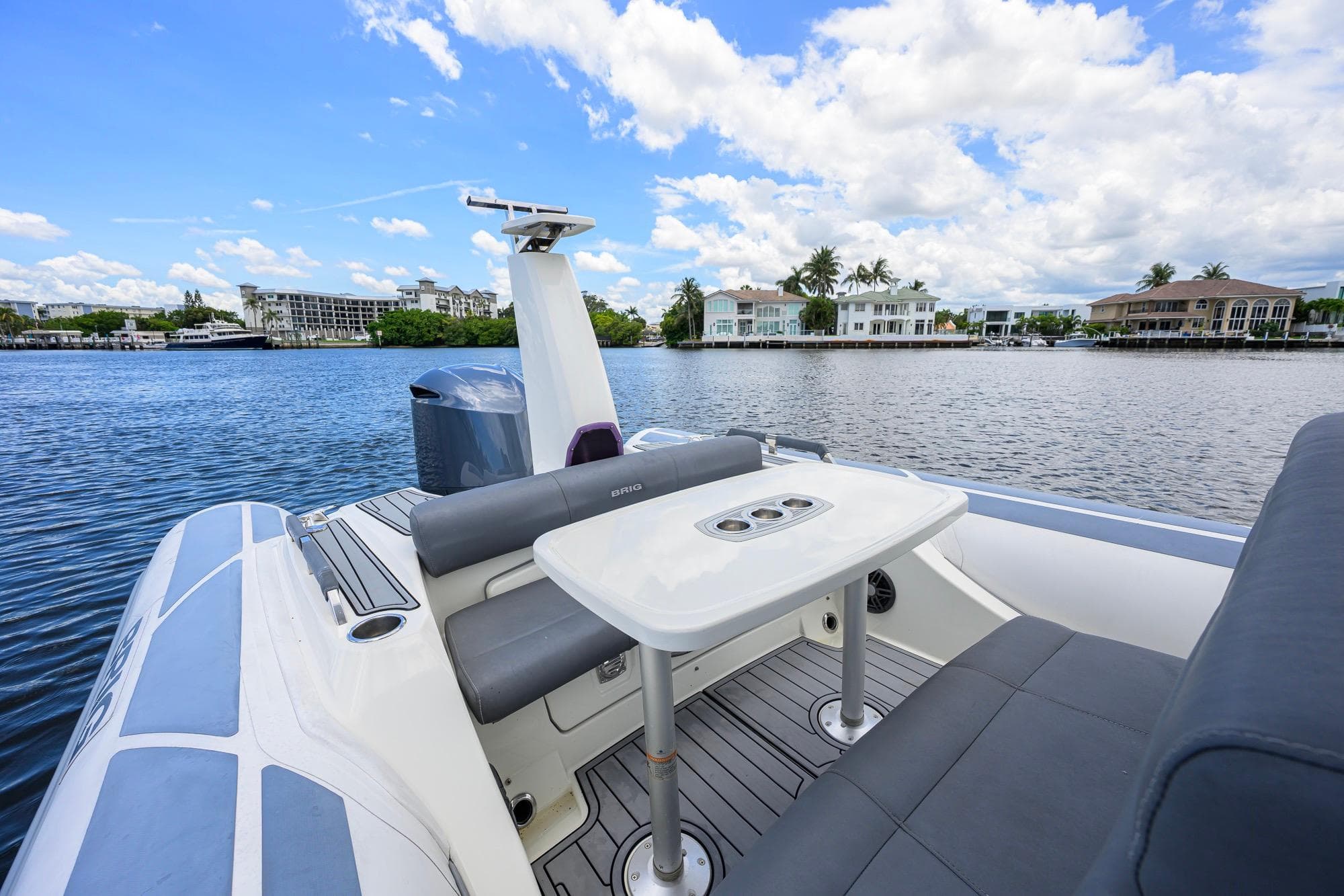 2021 Brig Eagle 8 boat with seating and table on a scenic waterfront.