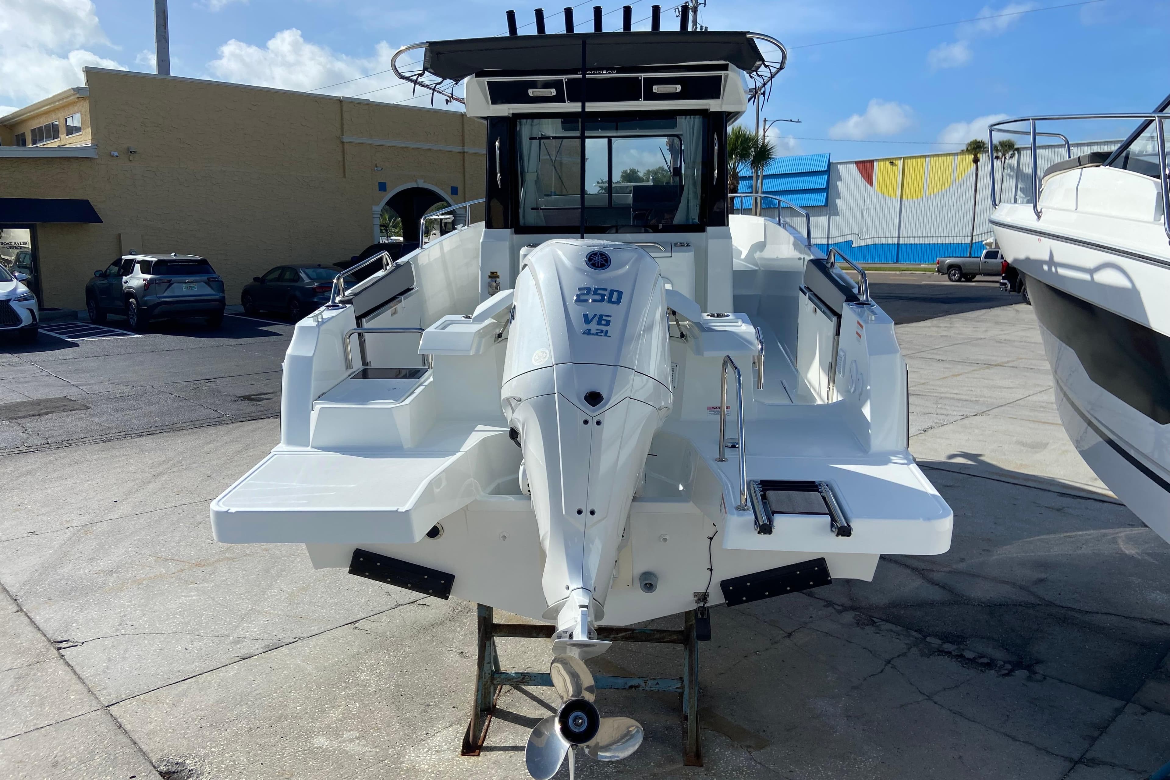 2026 Jeanneau NC Sport 795 Series 2 boat with powerful outboard motor, docked outdoors.