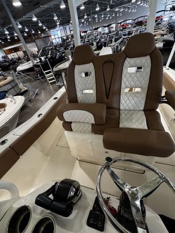 2025 Pioneer Pelagic 270 boat interior with brown and white seating in a showroom.