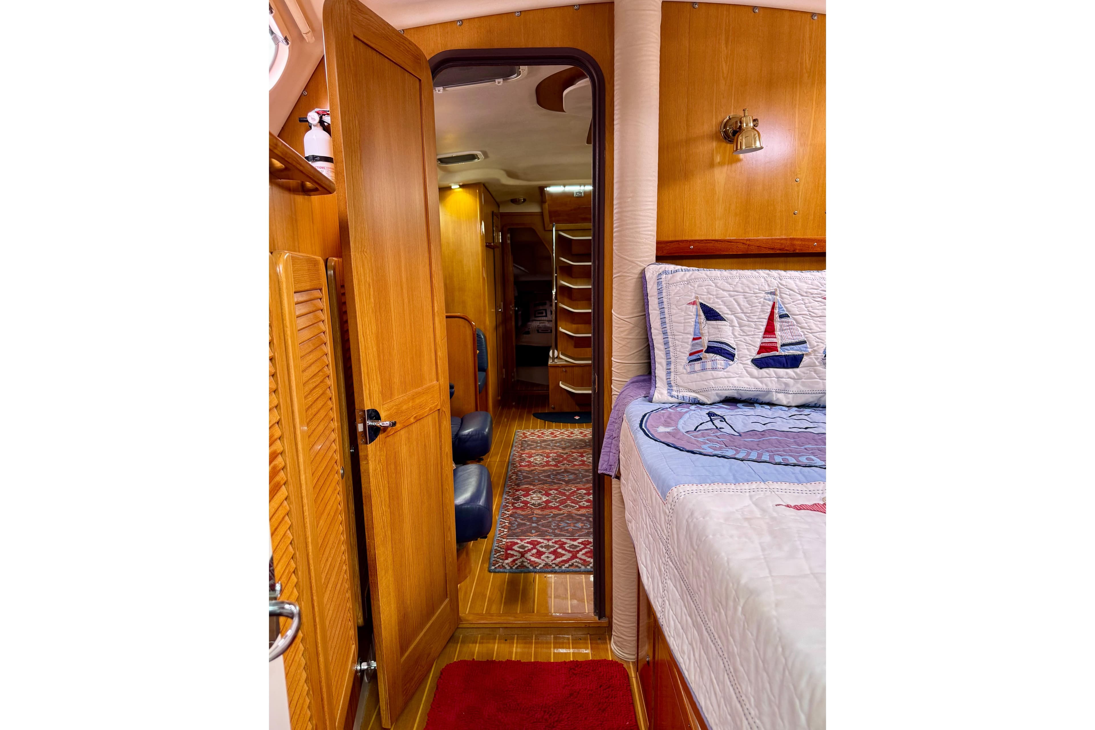 Interior of 2005 Catalina 470 yacht, featuring cozy cabin with nautical-themed bedding.