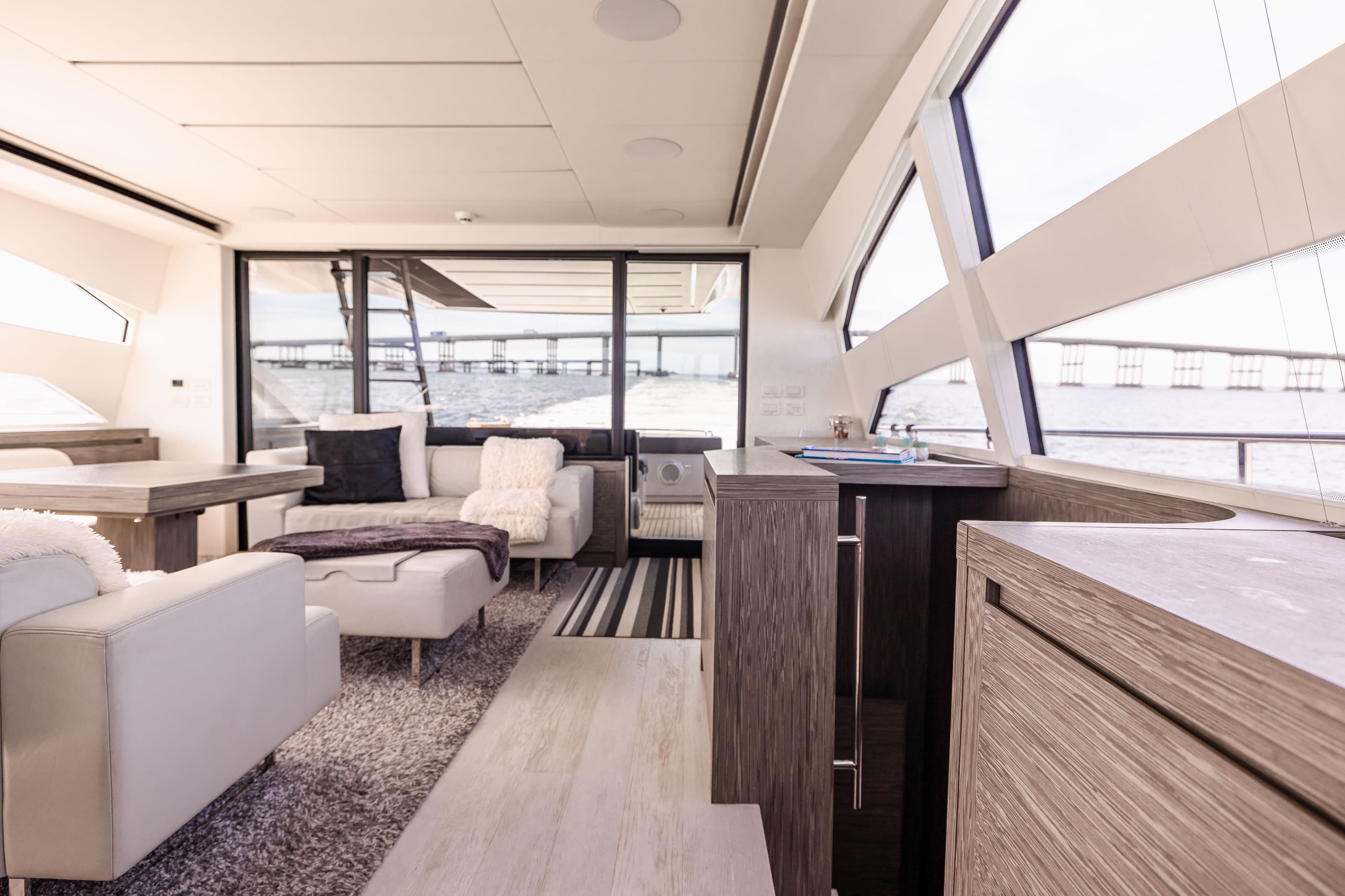 Luxurious interior of 2017 Pershing 82 VHP yacht with modern furnishings and panoramic windows.