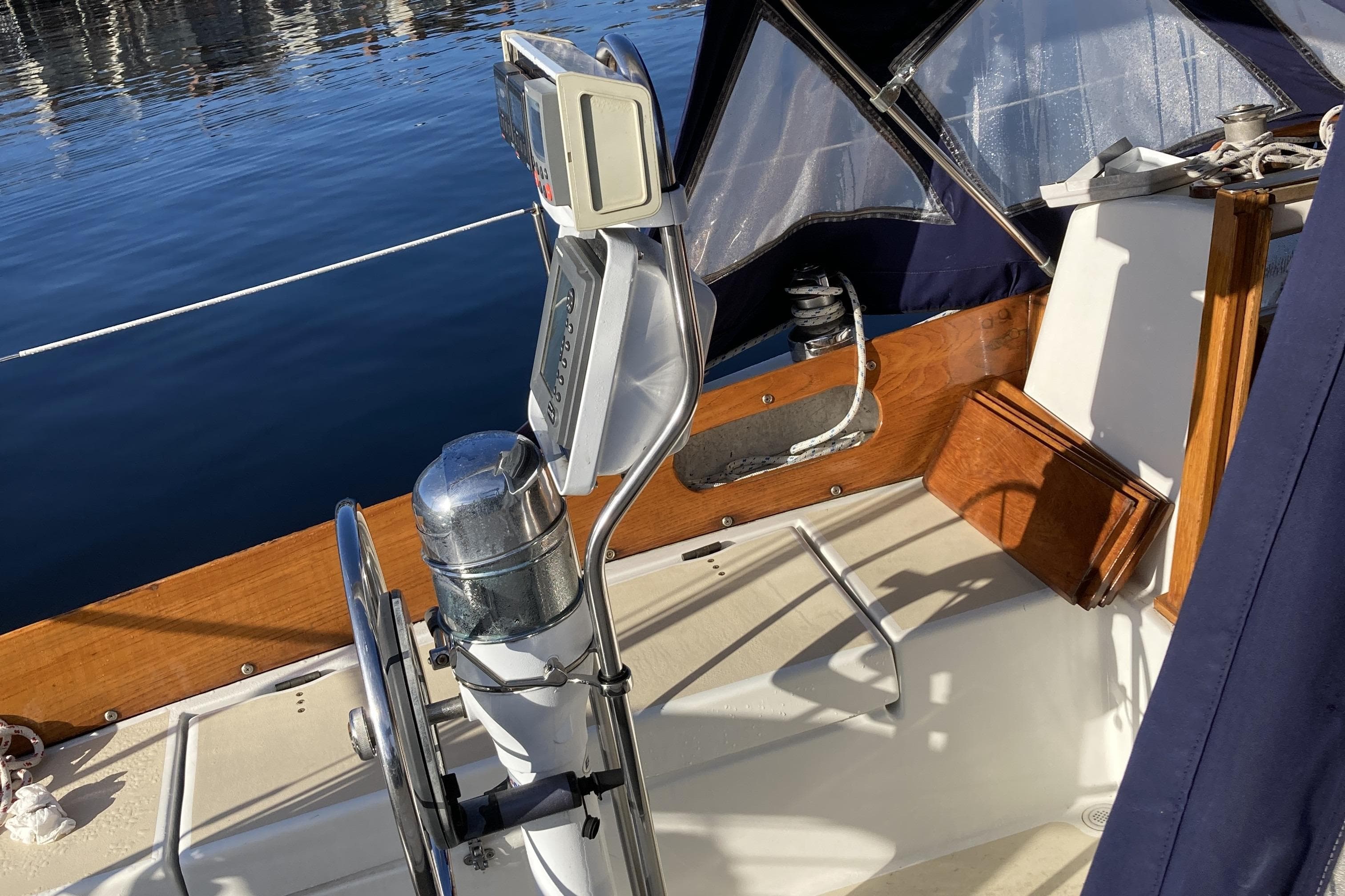 Cockpit of a 1971 Luders 33 sailboat with steering wheel and navigation equipment.