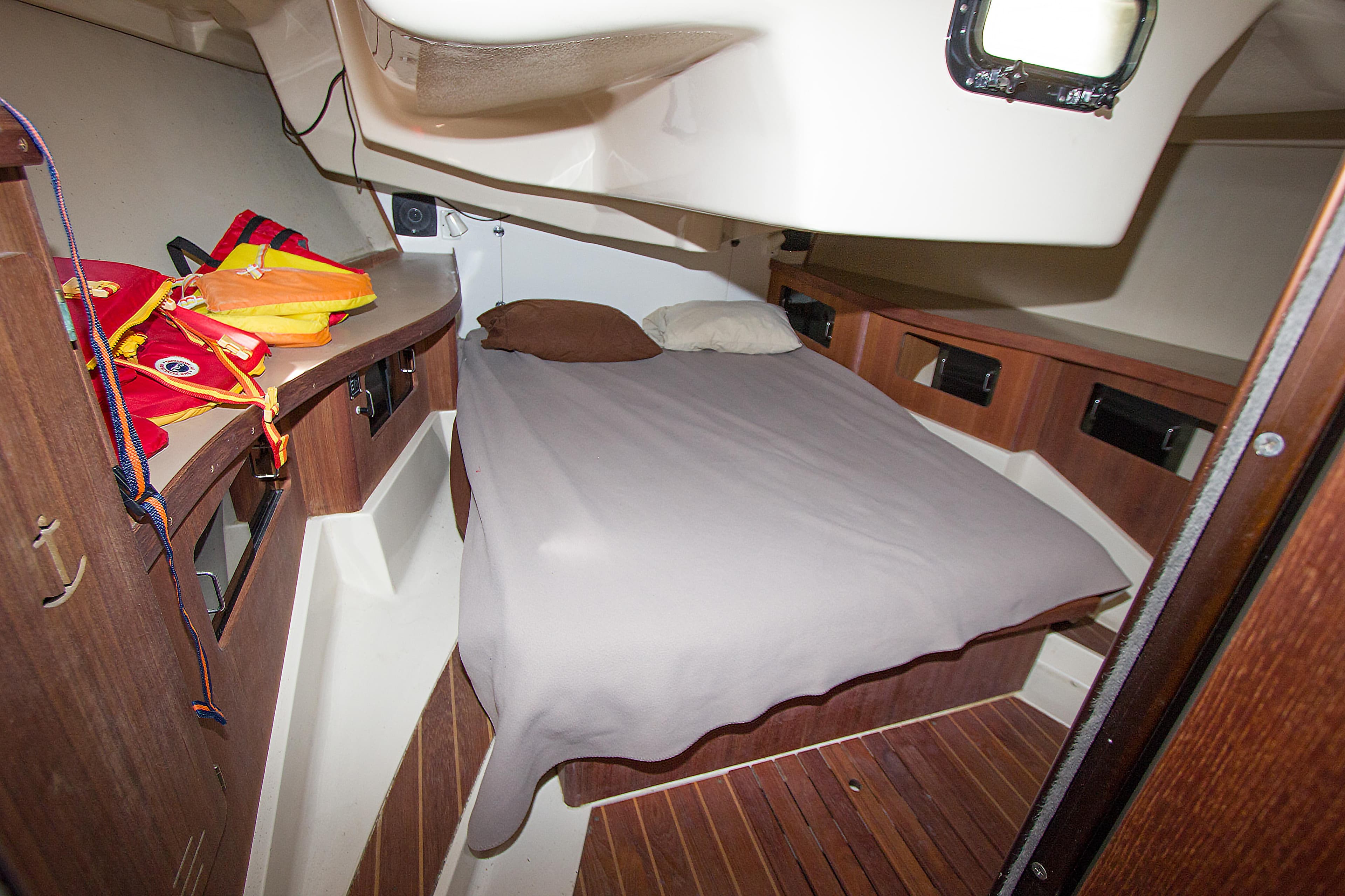 Interior cabin of 1989 Hunter 37.5 sloop with bed and wooden cabinetry.