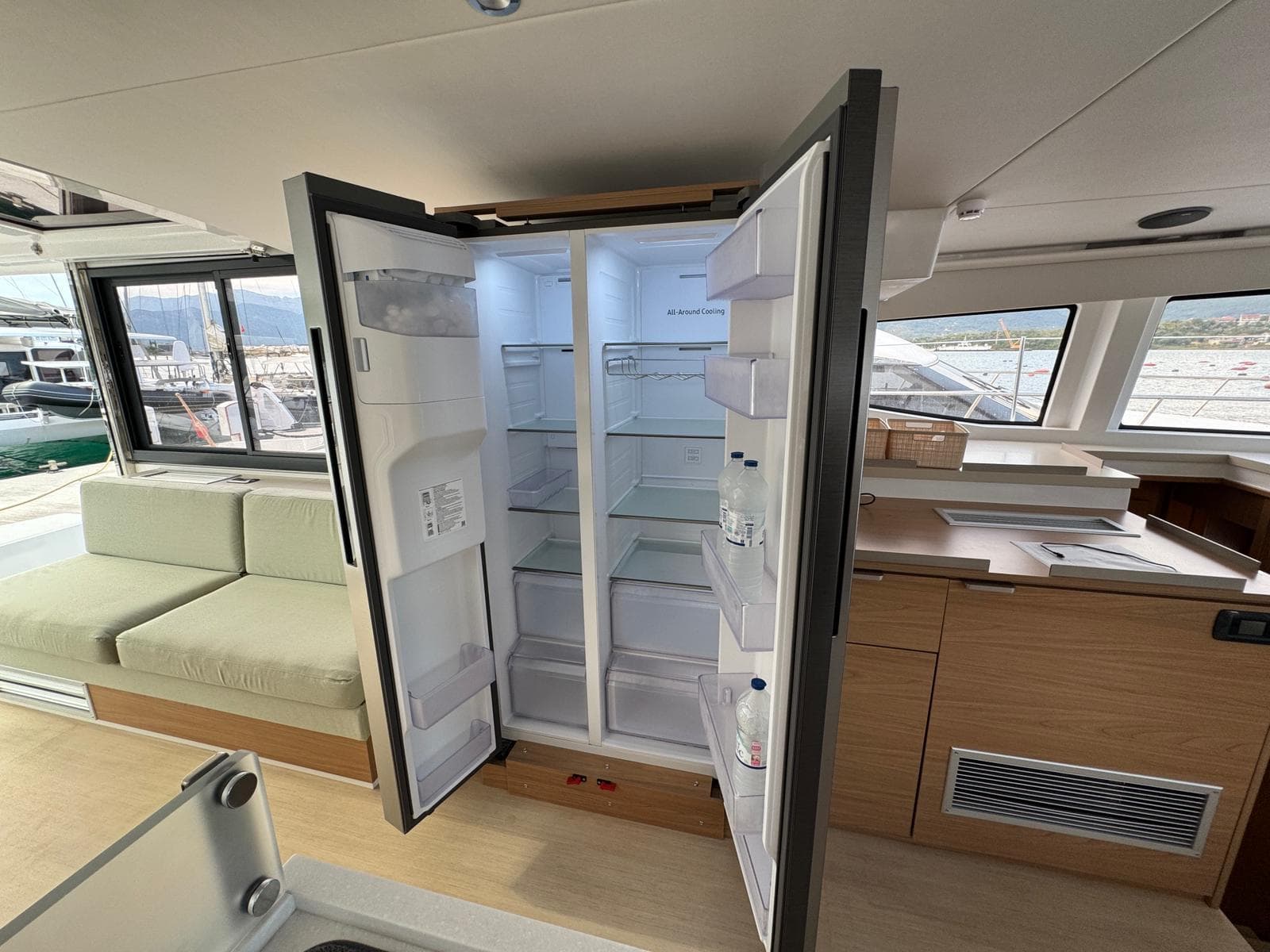 Modern kitchen interior of 2025 Bali 4.8 Open Space yacht with open refrigerator.