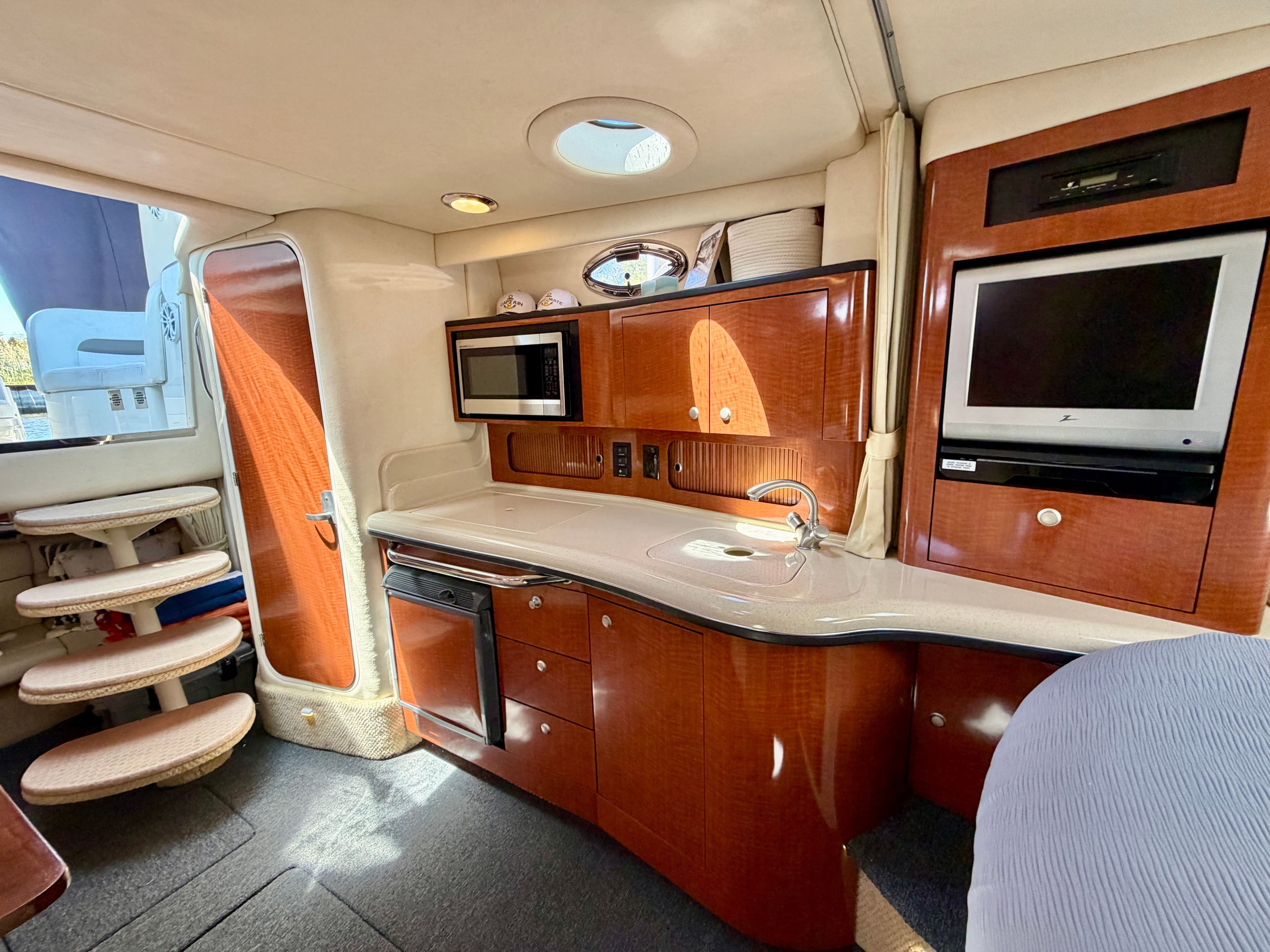 Interior of a 2005 Sea Ray Sundancer 320 yacht with kitchen and TV.