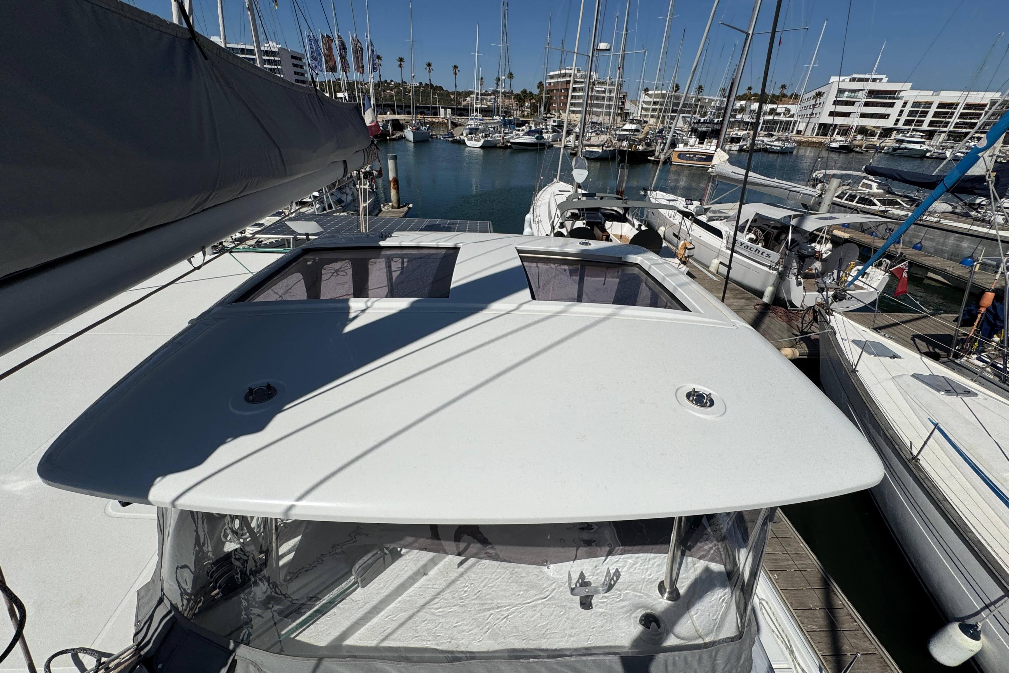 2020 Lagoon 42 catamaran docked in a marina, surrounded by sailboats.