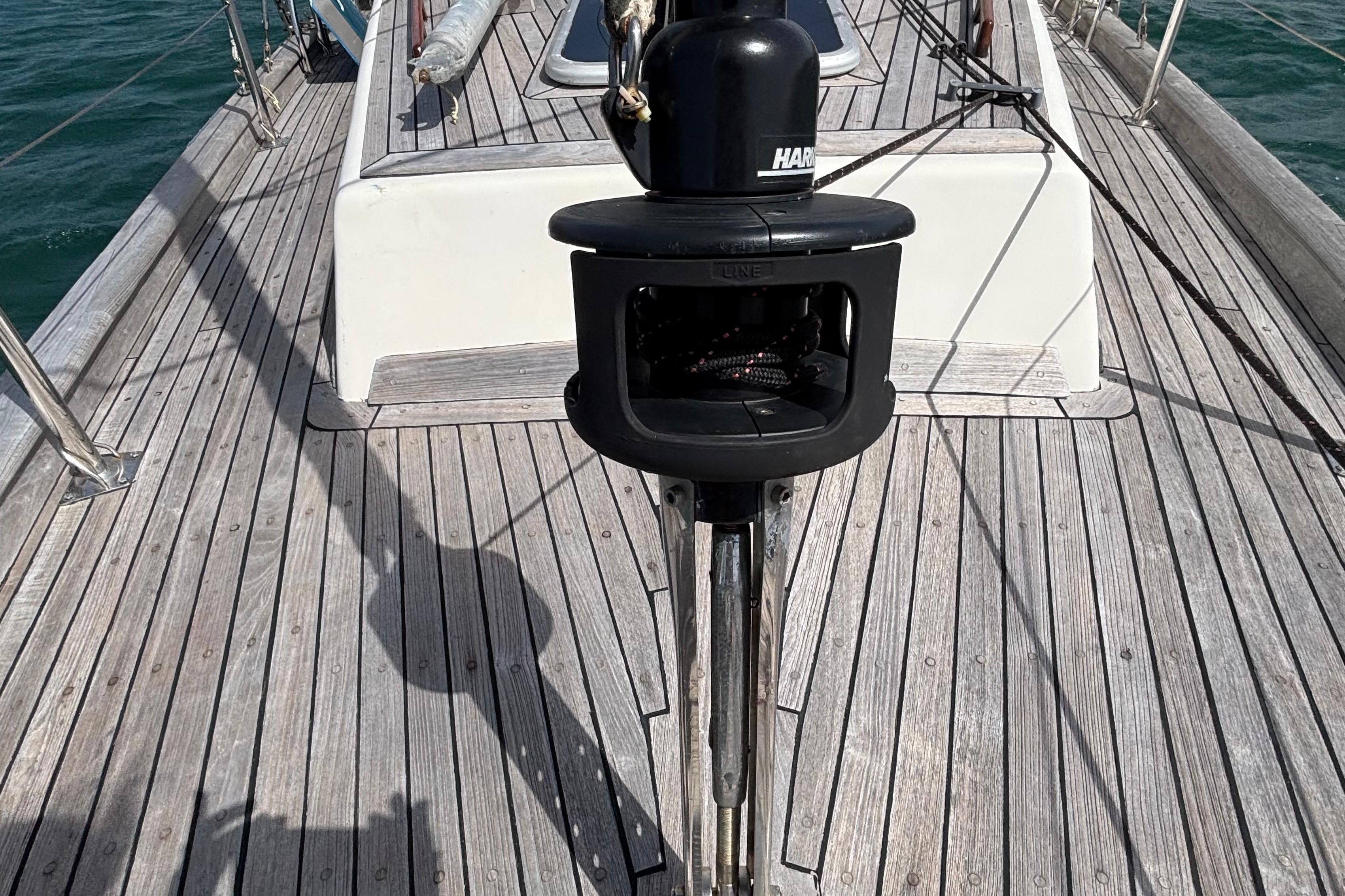 Deck of 1981 Bruce Roberts Offshore 45 sailboat with winch and wooden planks.