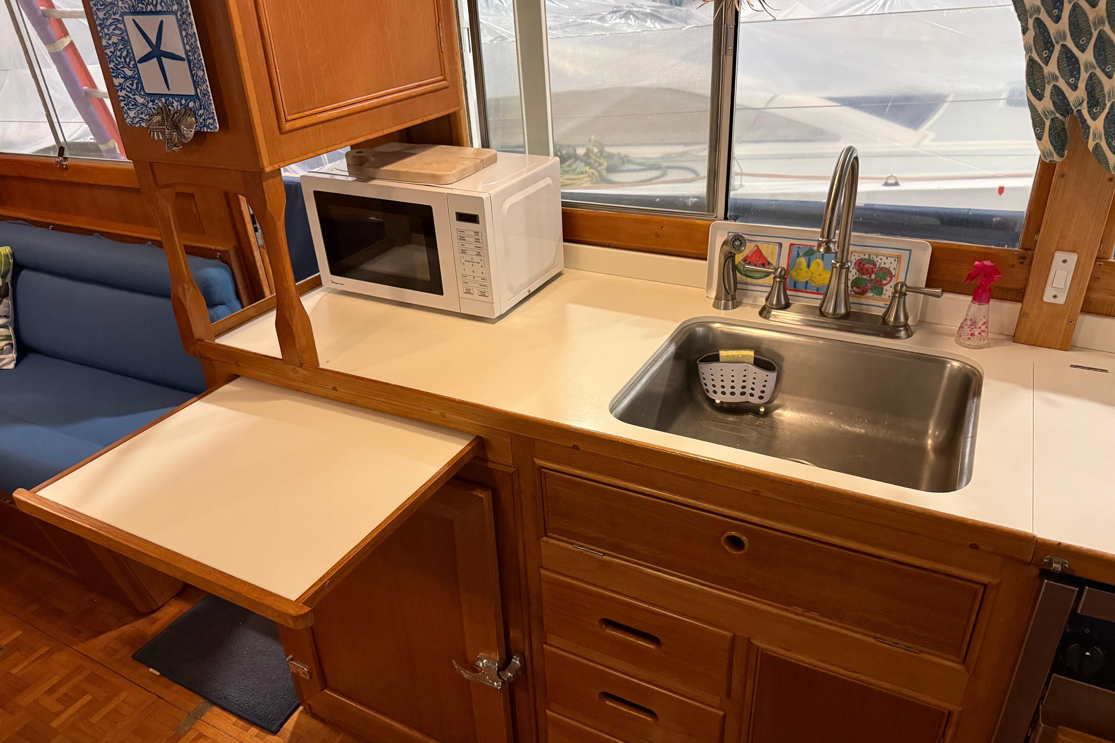 1991 Grand Banks 42 Classic kitchen with sink, microwave, and wooden cabinetry.
