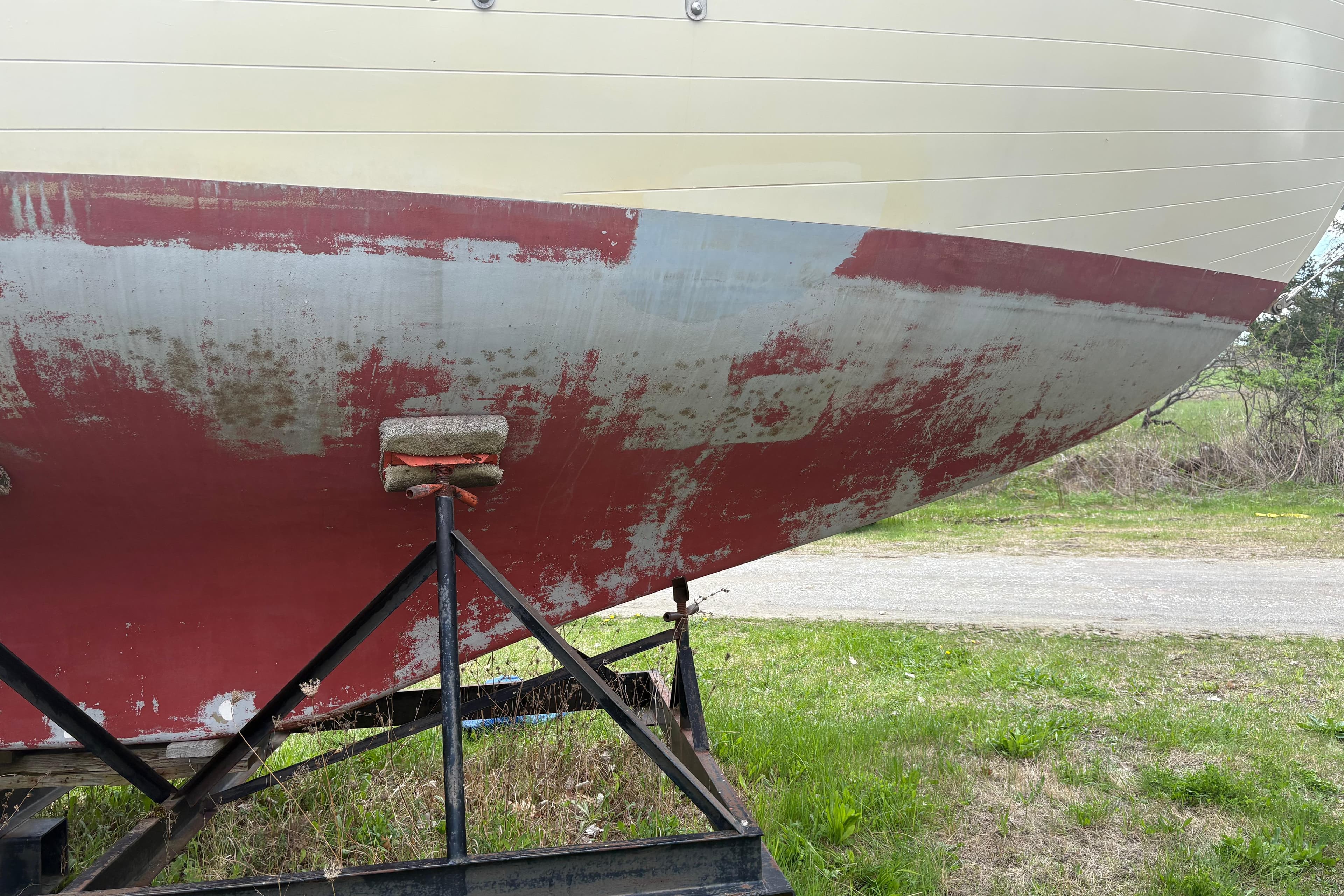 1978 Pacific Seacraft 31 sailboat hull on a trailer, showing wear and paint peeling.