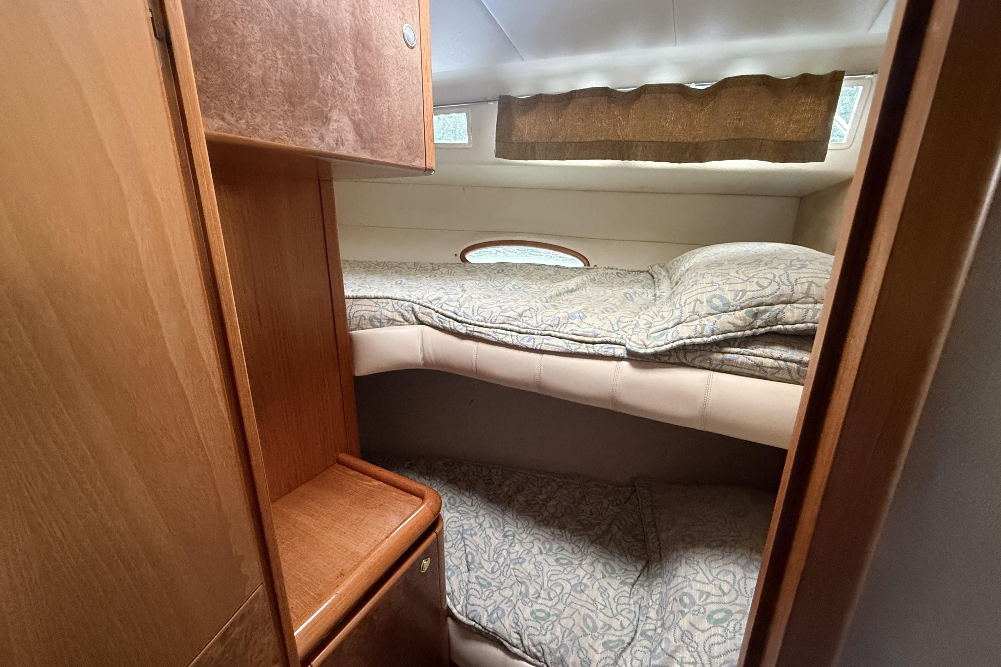 Interior cabin of 2000 Royal Pacific 476 Sport Cruiser with bunk beds and wooden cabinetry.