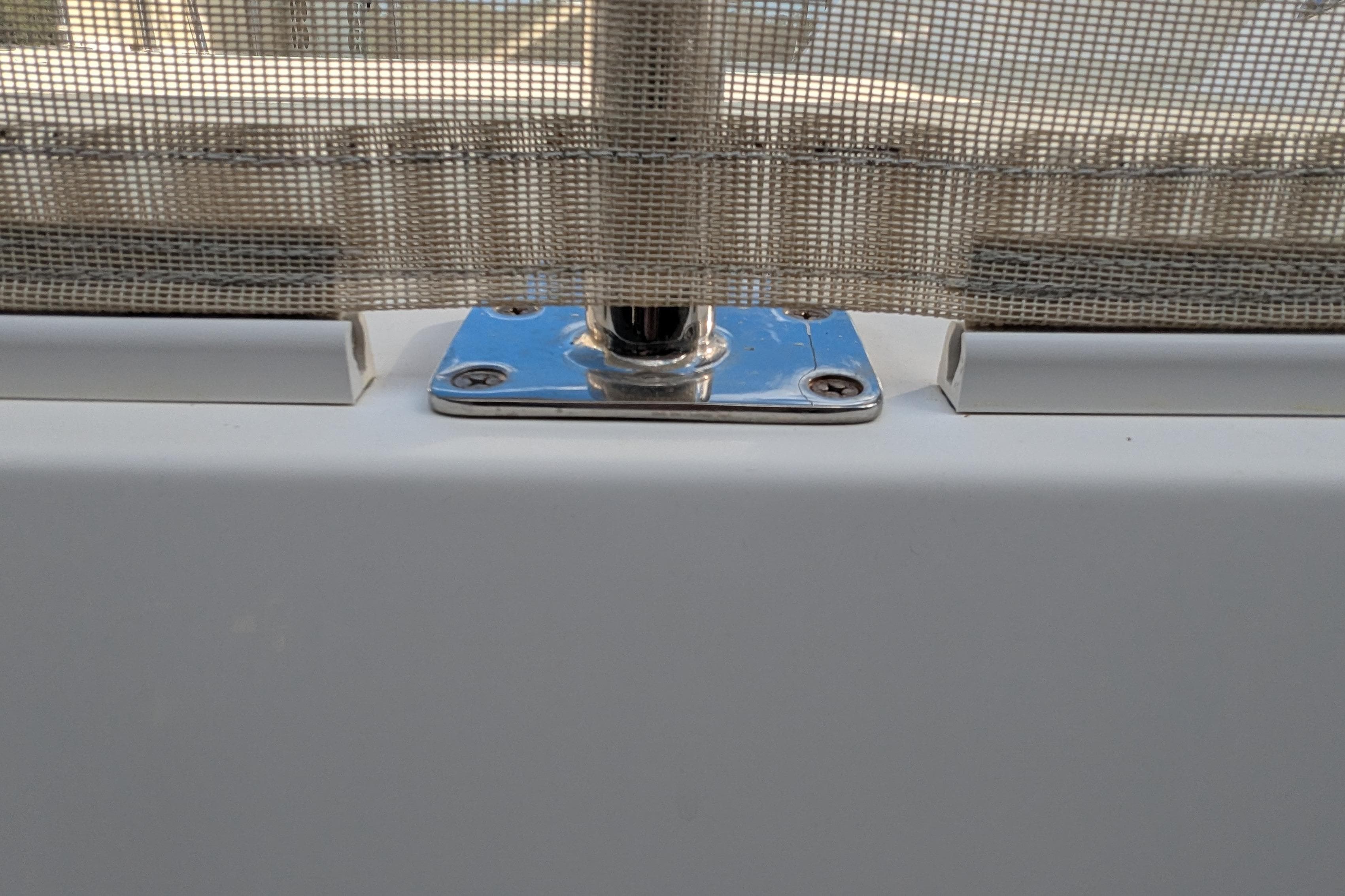 Close-up of a 2005 Kadey-Krogen Pilothouse window frame with metal fittings.