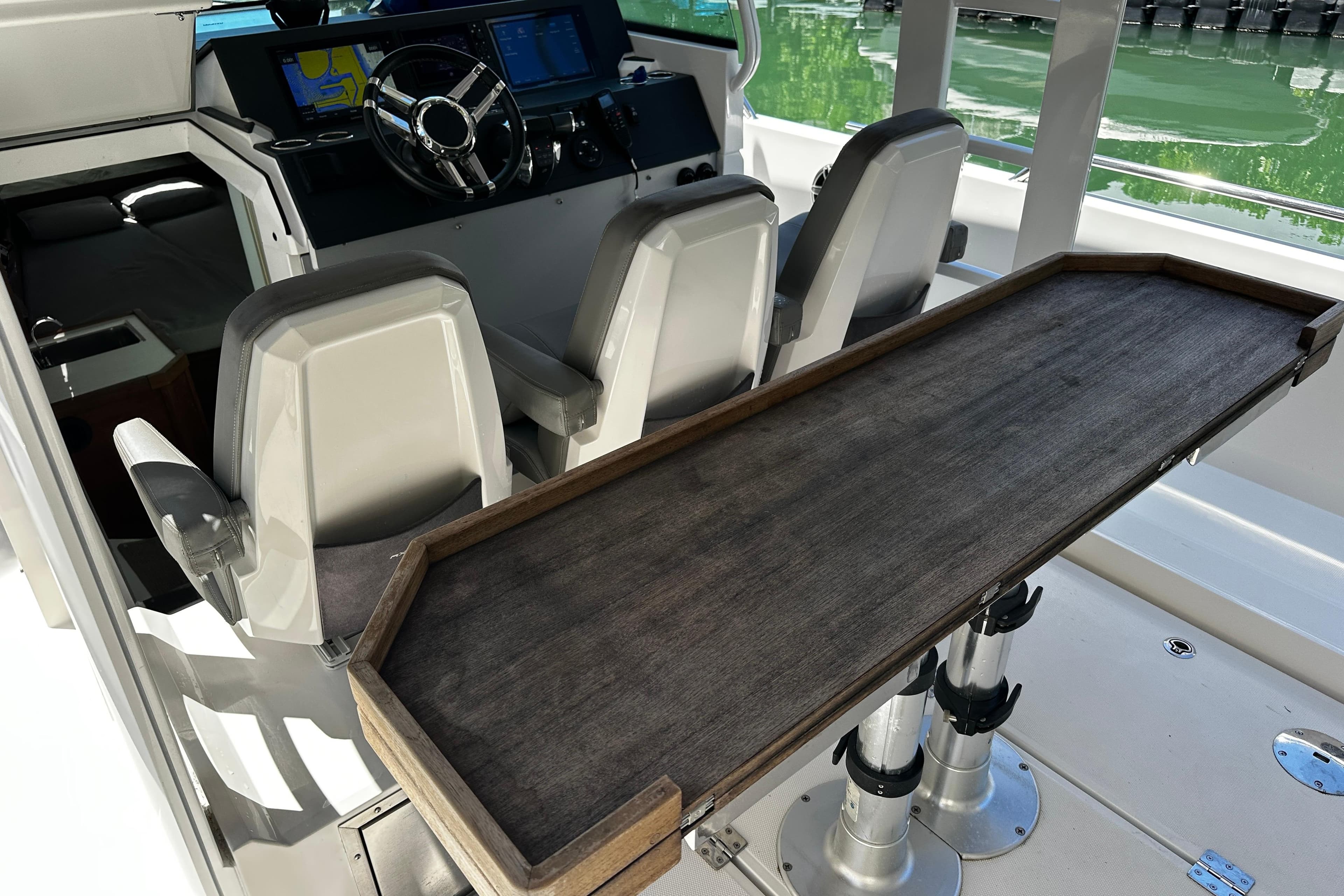 2018 Axopar 37 Sun-Top boat interior with helm, seating, and wooden table.