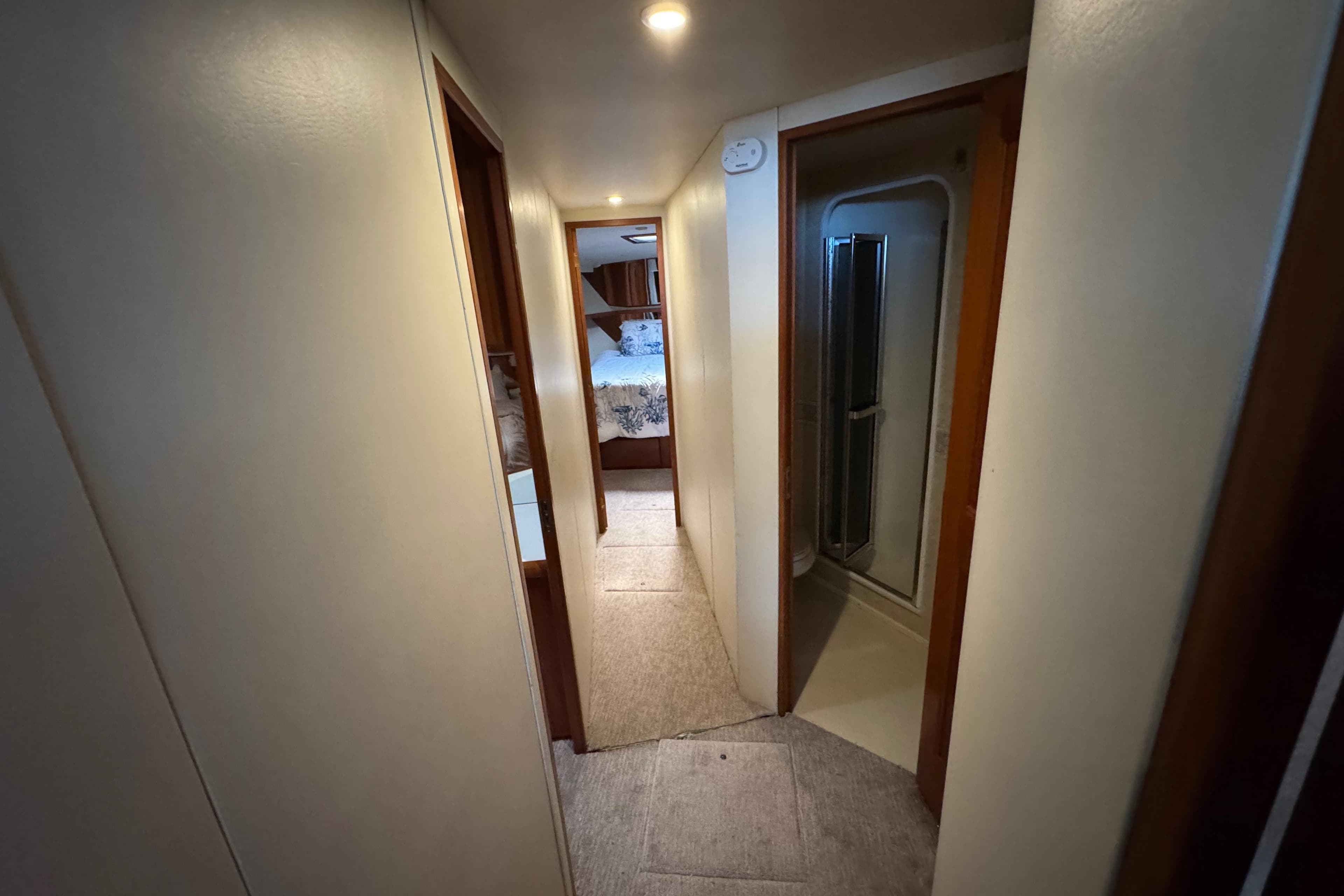 Hallway inside 1995 Viking 58 Convertible yacht, featuring bedroom and bathroom access.