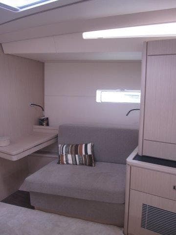 Modern interior of 2024 Jeanneau 55 yacht with cozy seating area.
