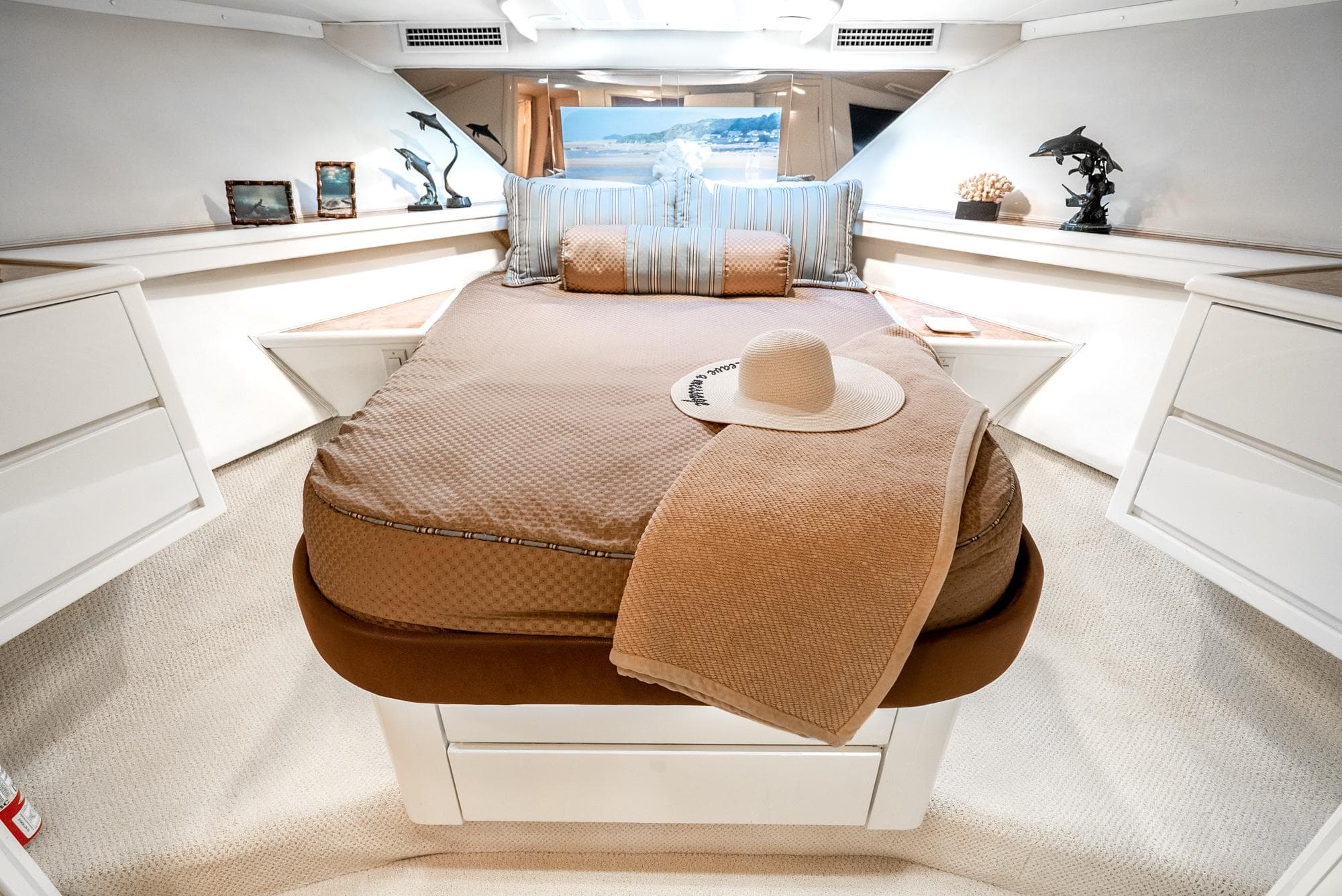 Luxurious cabin interior of 1990 Hatteras 58 Sportfish yacht with elegant bedding and decor.