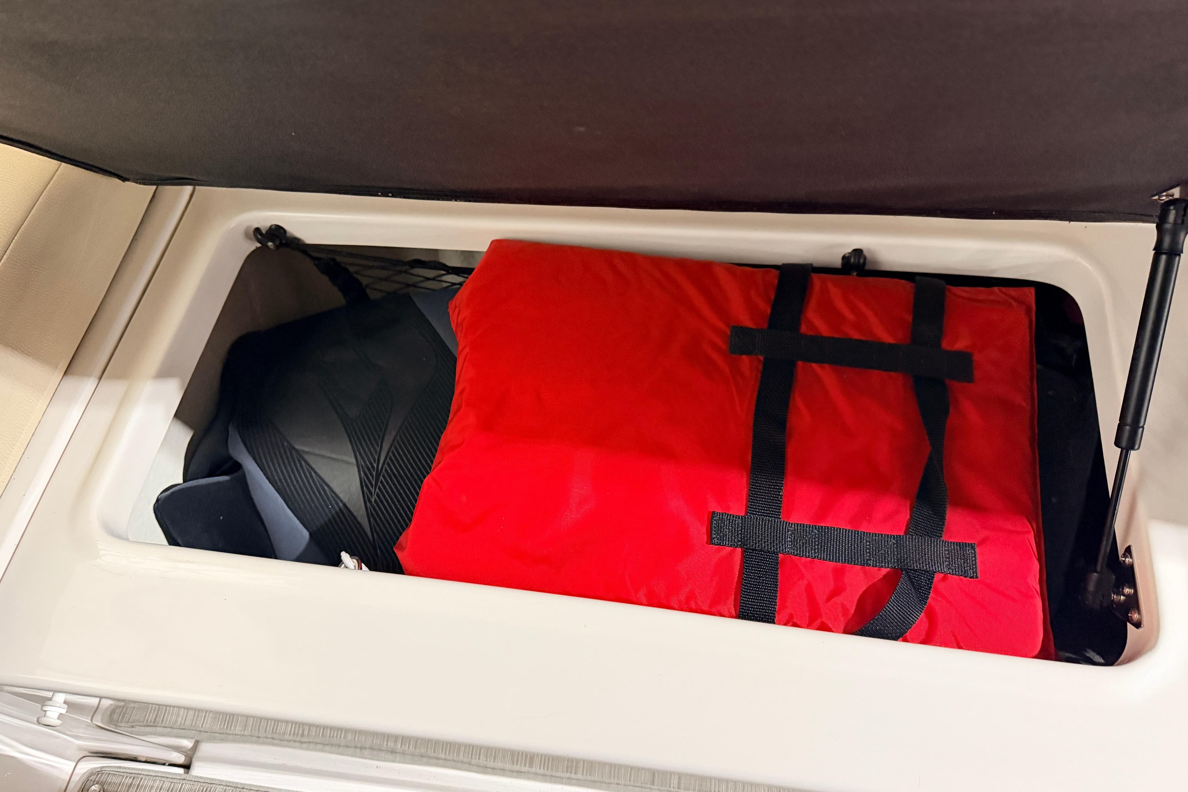 Storage compartment in 2019 Regal 42 Grande Coupe with red life jacket.