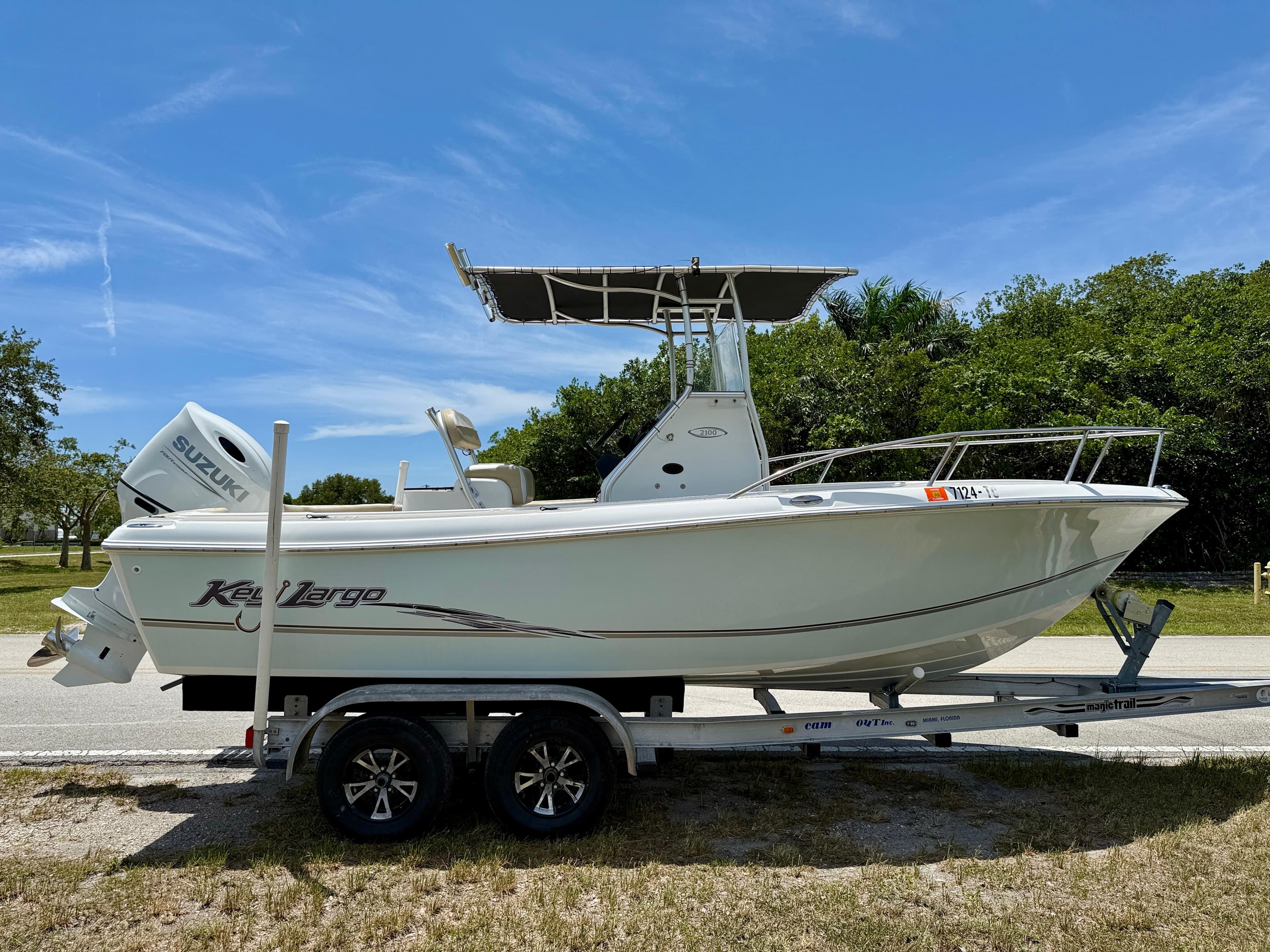 2016 Key Largo 2100 WI CC boat on trailer, clear sky, lush greenery background.