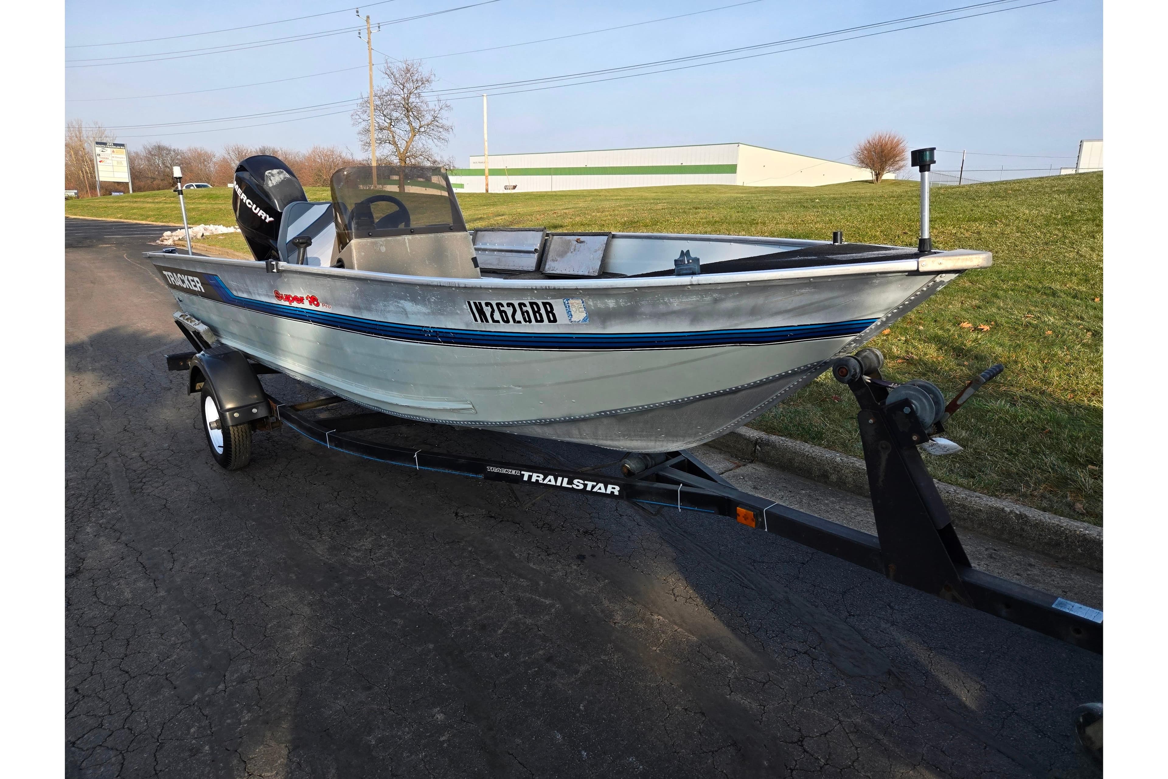 1994 Tracker Pro Deep V-16 boat on trailer, parked on paved road.