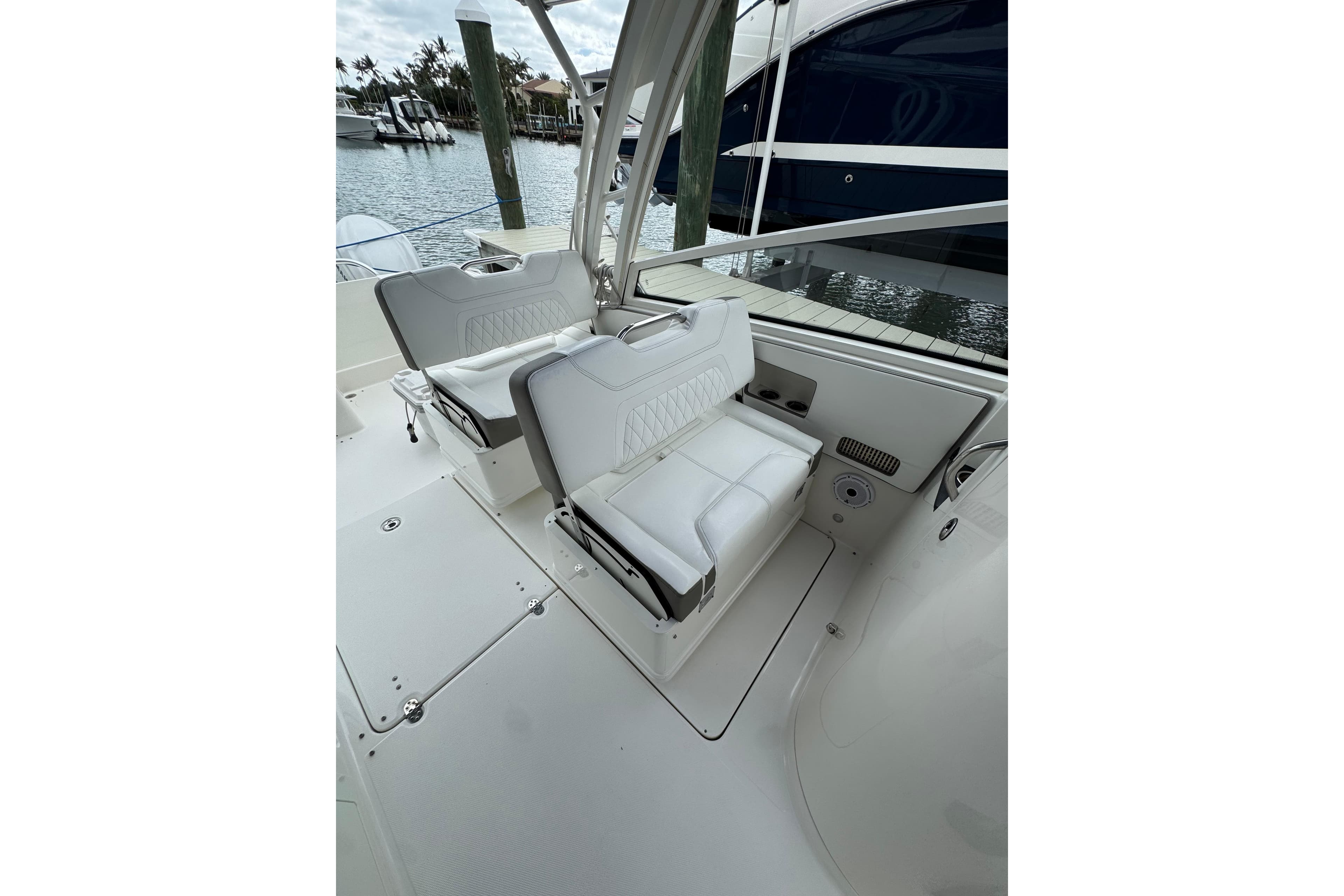 2022 World Cat 325 DC boat interior with white seating, docked by the water.
