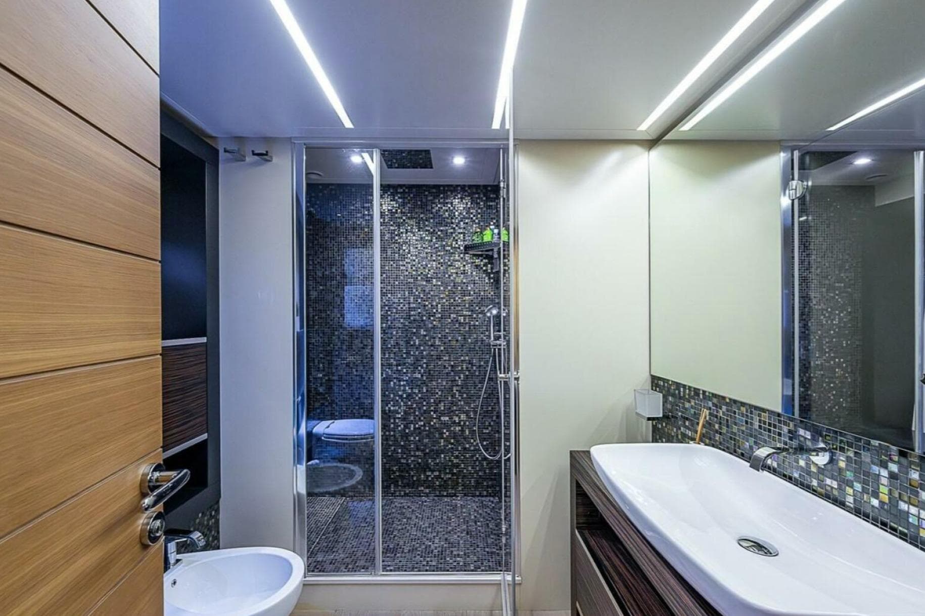 Luxurious bathroom on 2014 Pershing 92 yacht with modern fixtures and mosaic tiles.